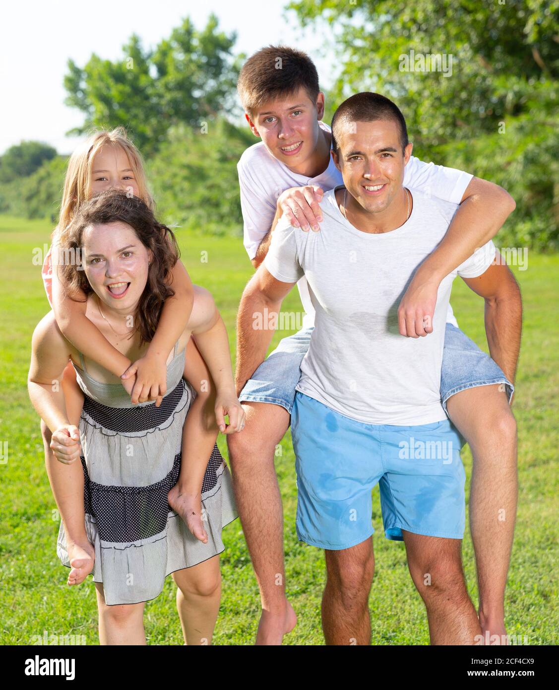 Famille de quatre personnes jouant dans le parc d'été Banque D'Images