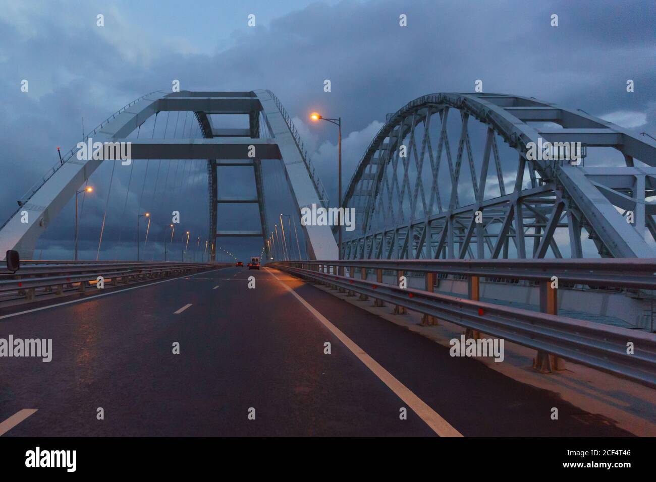Les voitures se trouvent sous les arches du pont de Crimée en fin de soirée. Les feux sont allumés. Terne Banque D'Images