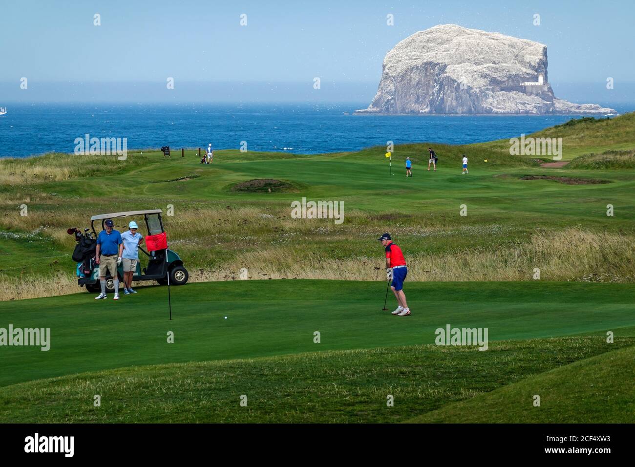 Golfeurs sur 16th Green of Glen Golf course, North Berwick - Bass Rock à distance Banque D'Images