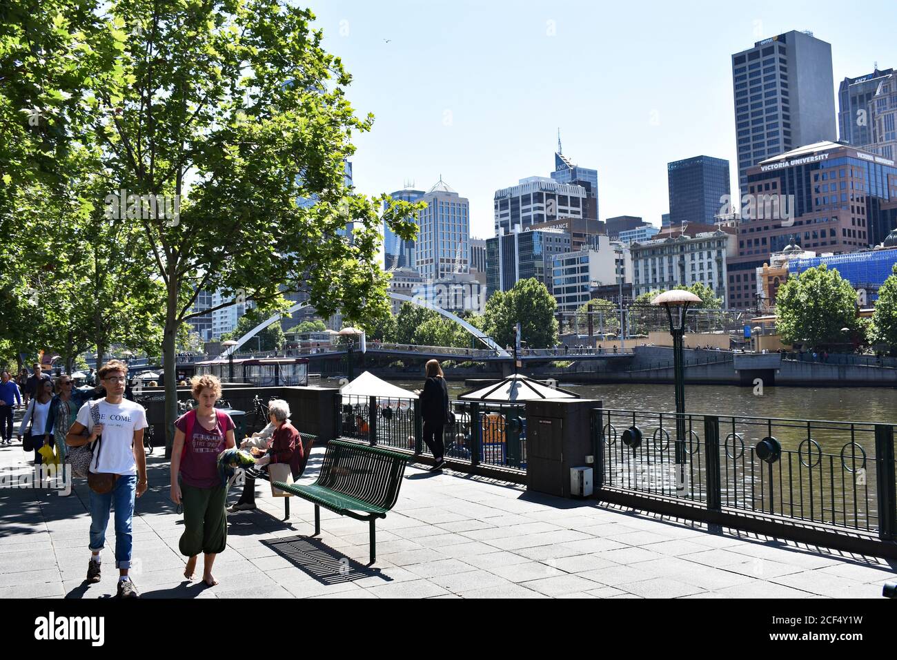 Les gens marchent le long de la promenade Southbank dans le centre-ville de Melbourne lors d'une journée ensoleillée. Le fleuve Yarra traverse le centre-ville. Banque D'Images