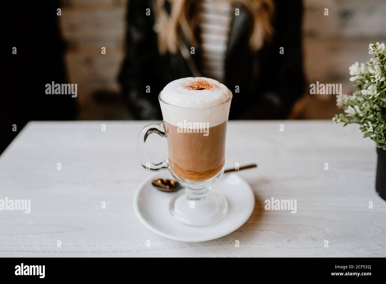 Courte inreconnaissable tendance belle femme blonde boire d'un verre de délicieux café mousseux Banque D'Images