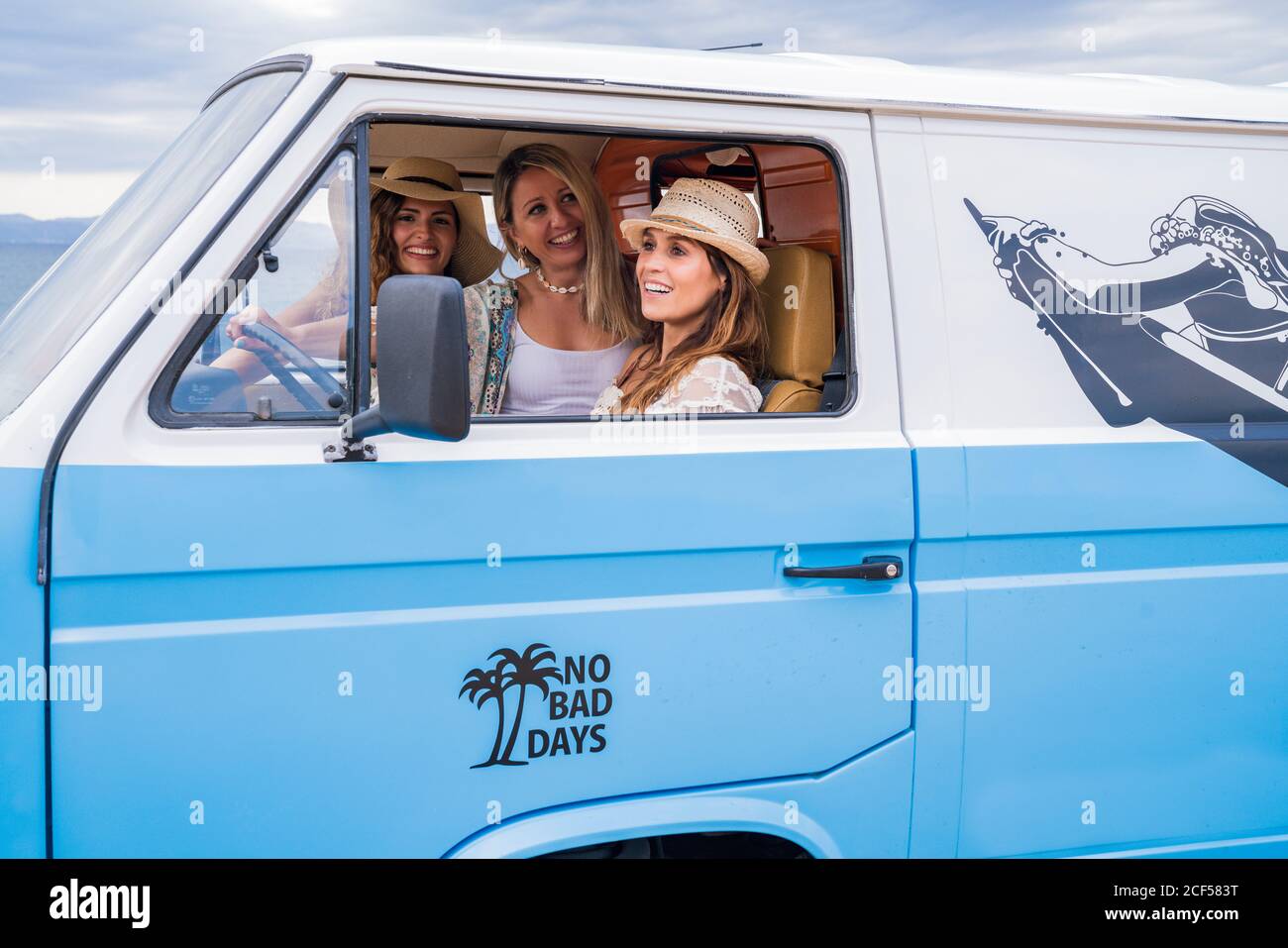 Gaies et charmantes dames en chapeaux de voyage en bleu voiture en journée Banque D'Images