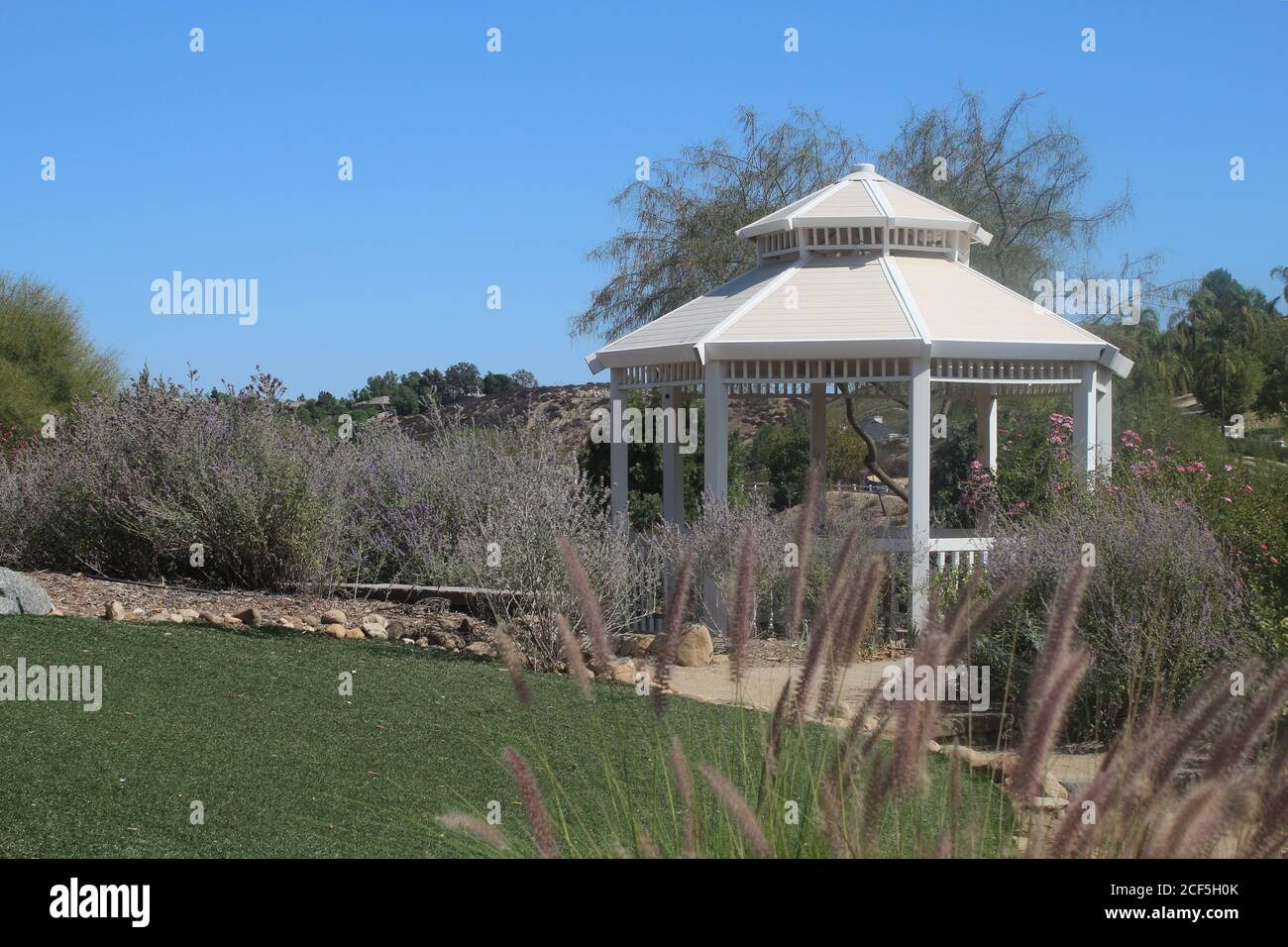 Belvédère blanc situé au milieu d'un jardin mature Banque D'Images