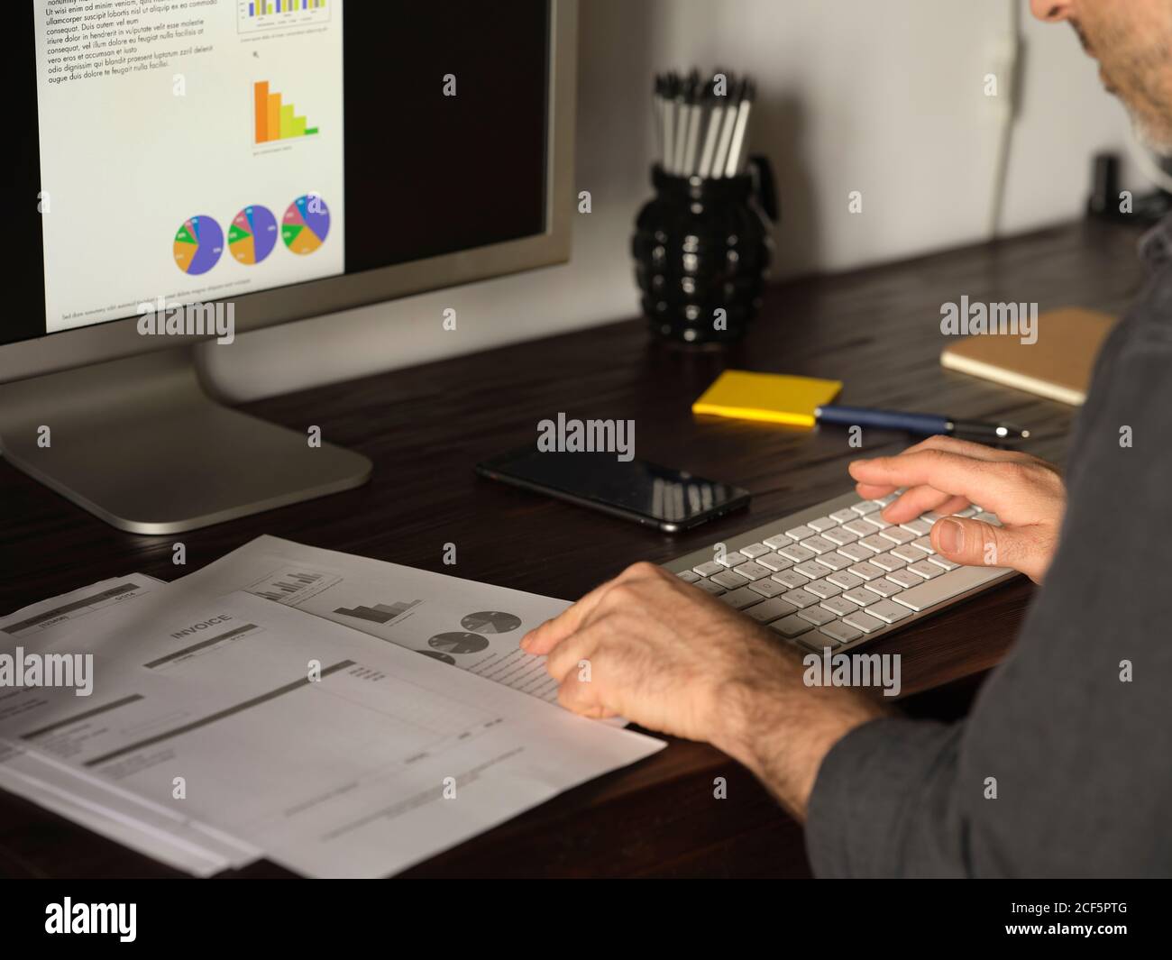 Détail des mains de l'homme travaillant à la maison bureau avec ordinateur Sur Internet, en examinant les statistiques et les factures Banque D'Images