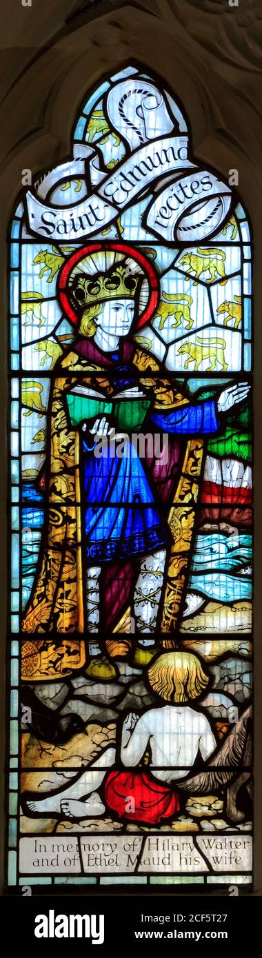 Saint-Edmund recite les Psaumes, vitrail du XXe siècle, église Saint-Edmund, Hunstanton, Norfolk. Falaises rayées de Hunstanton en arrière-plan Banque D'Images
