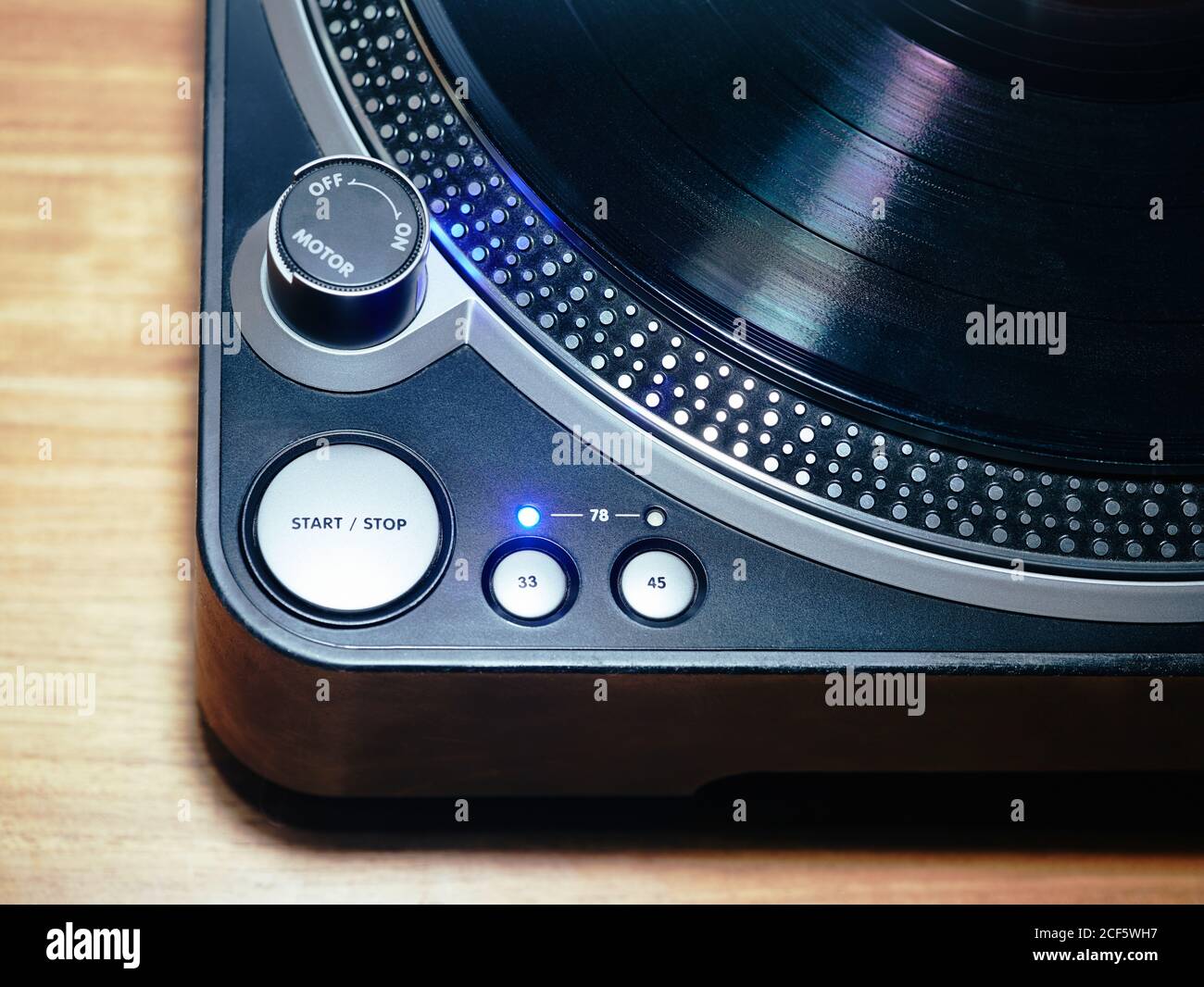 De plus en plus gros plan de la platine portable bleue avec enregistrement phonographique jeu de commandes et témoin lumineux allumé derrière 33 tr/min bouton Banque D'Images
