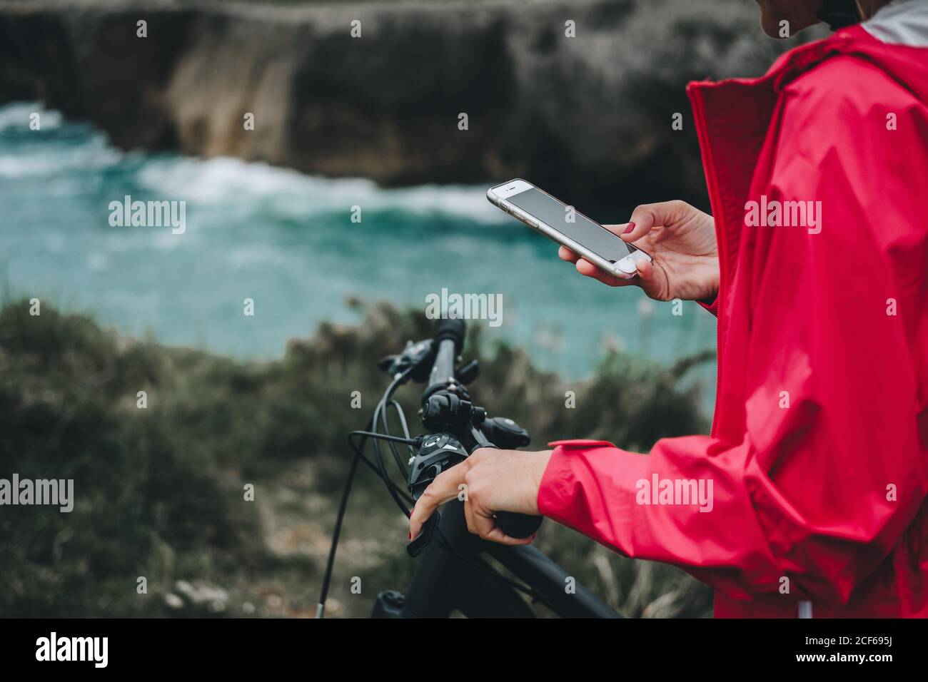 Vue rapprochée de la main d'une femme anonyme sur la navigation à vélo téléphone portable Banque D'Images
