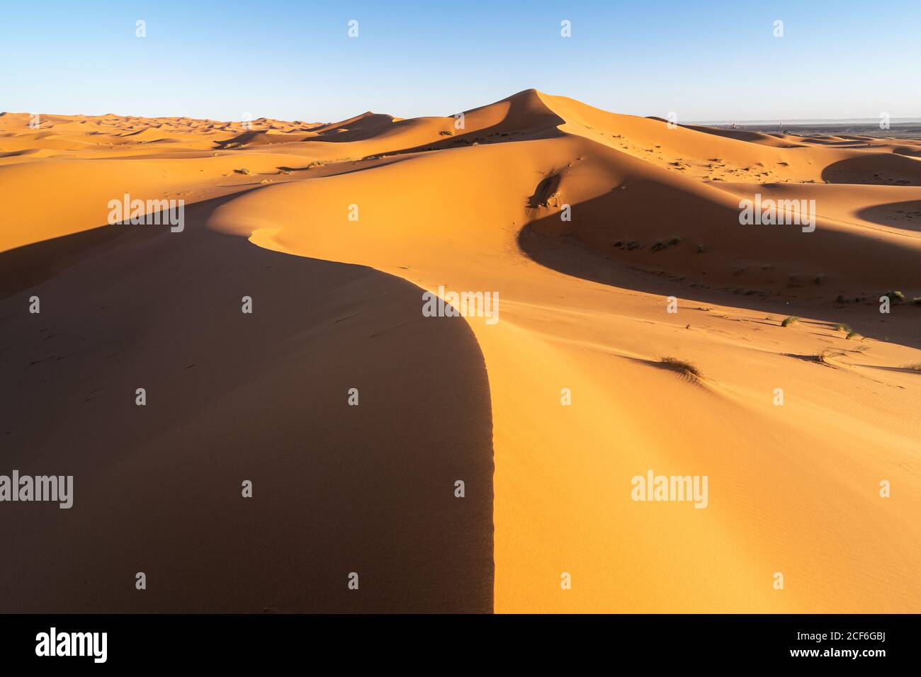 Paysage désertique minimaliste avec dunes de sable et ciel bleu clair Au Maroc Banque D'Images