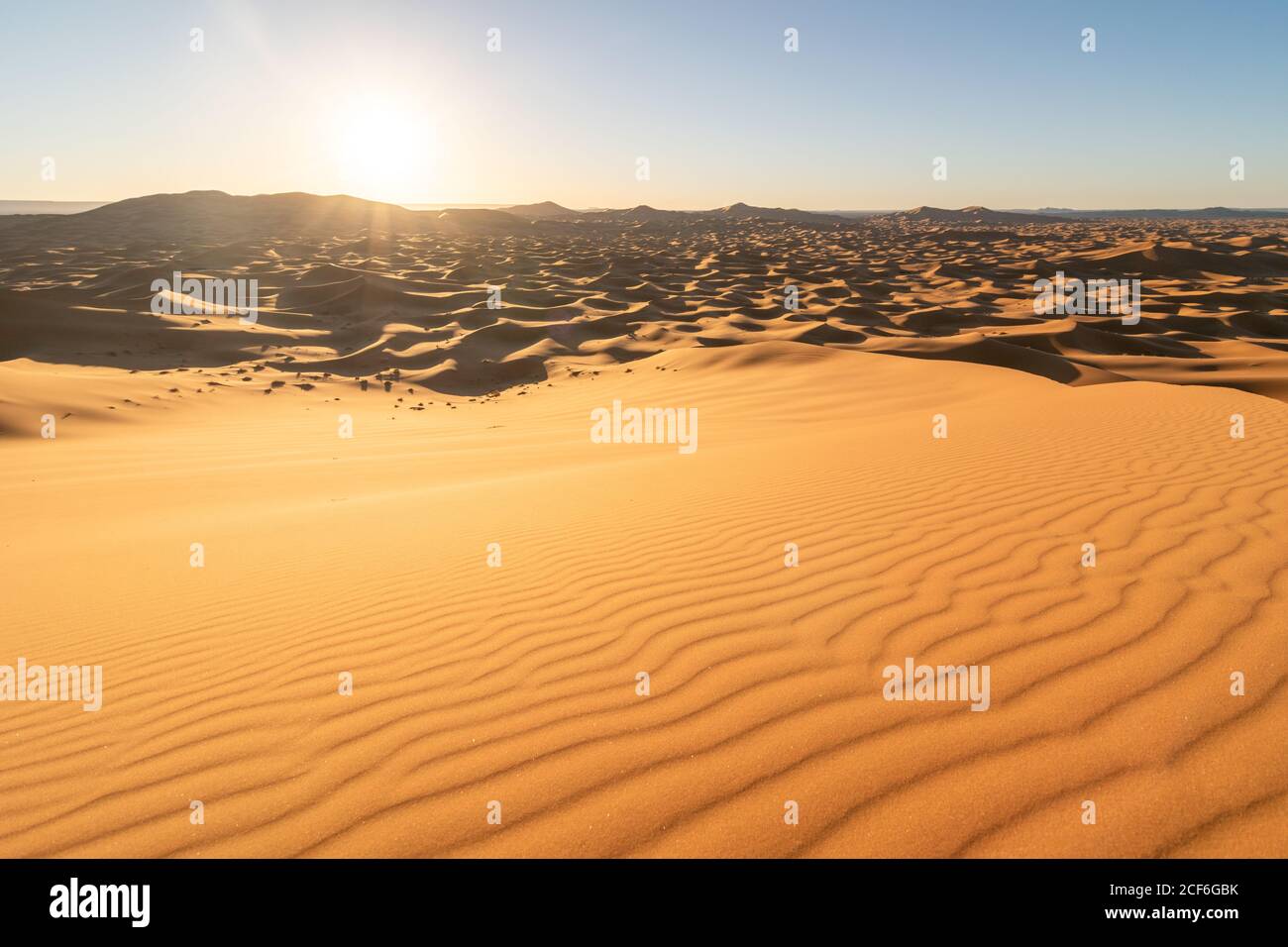 Paysage désertique minimaliste avec dunes de sable et ciel bleu clair Au Maroc Banque D'Images