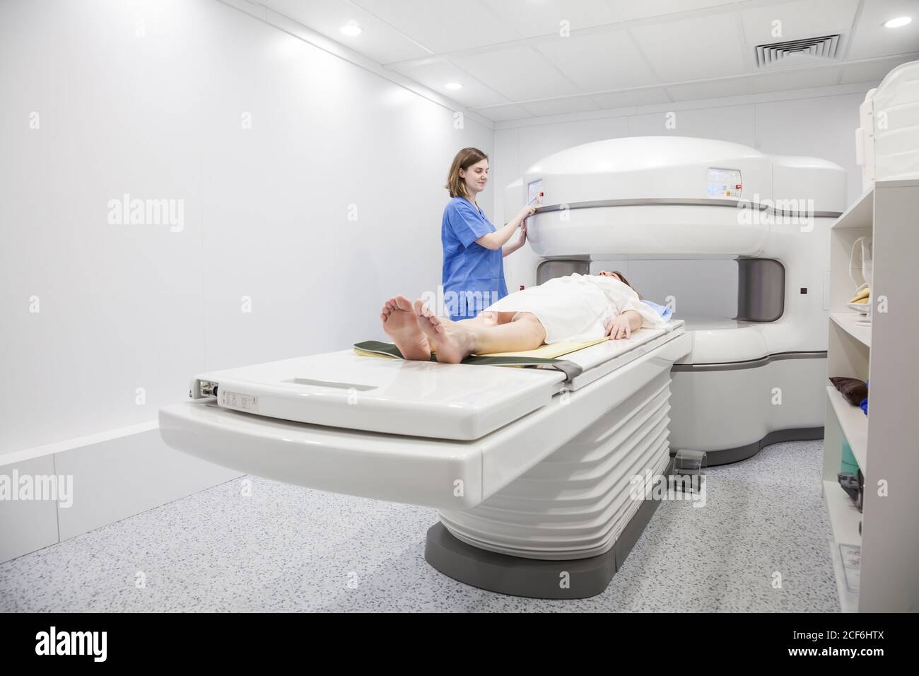 Une femme d'âge moyen et son médecin dans un appareil d'IRM ouvert attendant le début du test Banque D'Images