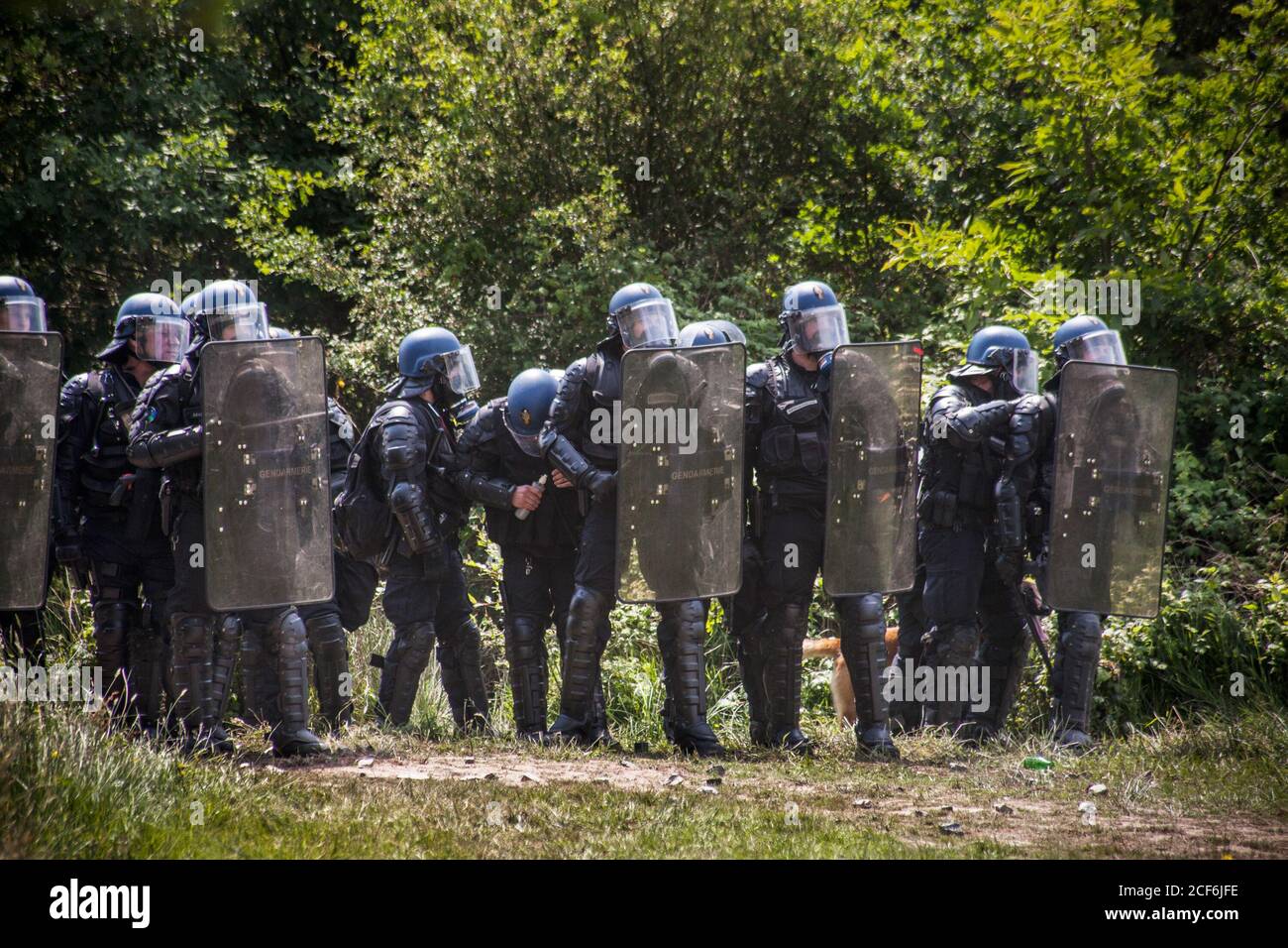 Une des forces anti-émeutes, la cinquième du côté droit, ouvrant une grenade à lancer vers le groupe activiste de la ZAD pendant la résistance.deuxième vague de confrontations, au cours d'une série d'expulsions qui ont duré une semaine sur le territoire français occupé la ZAD (zone de défense). Après 50 ans de combat contre le projet de construction de l'aéroport de Nantes et plus de 10 ans de squating sur le terrain de 4000 acres, 300 activistes qui vivent dans la région ont été attaqués par des militaires par le gouvernement qui voulait mettre fin au projet autonome. Un millier de policiers anti-émeutes ont détruit 80% de l'auto-constar Banque D'Images