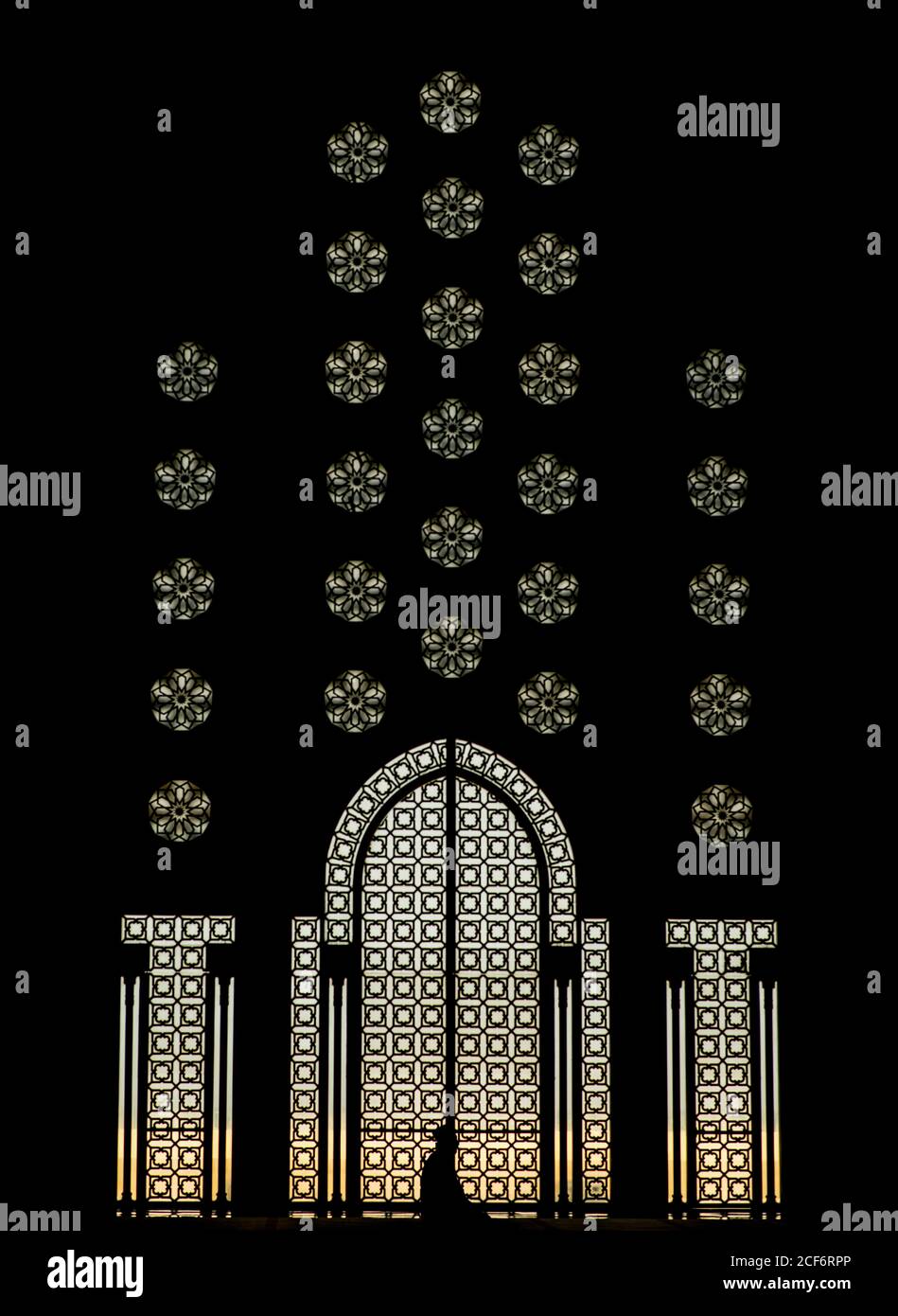 Silhouette de l'homme devant les portes et les fenêtres ornementales de bâtiment avec décoration élégante sur la façade Banque D'Images