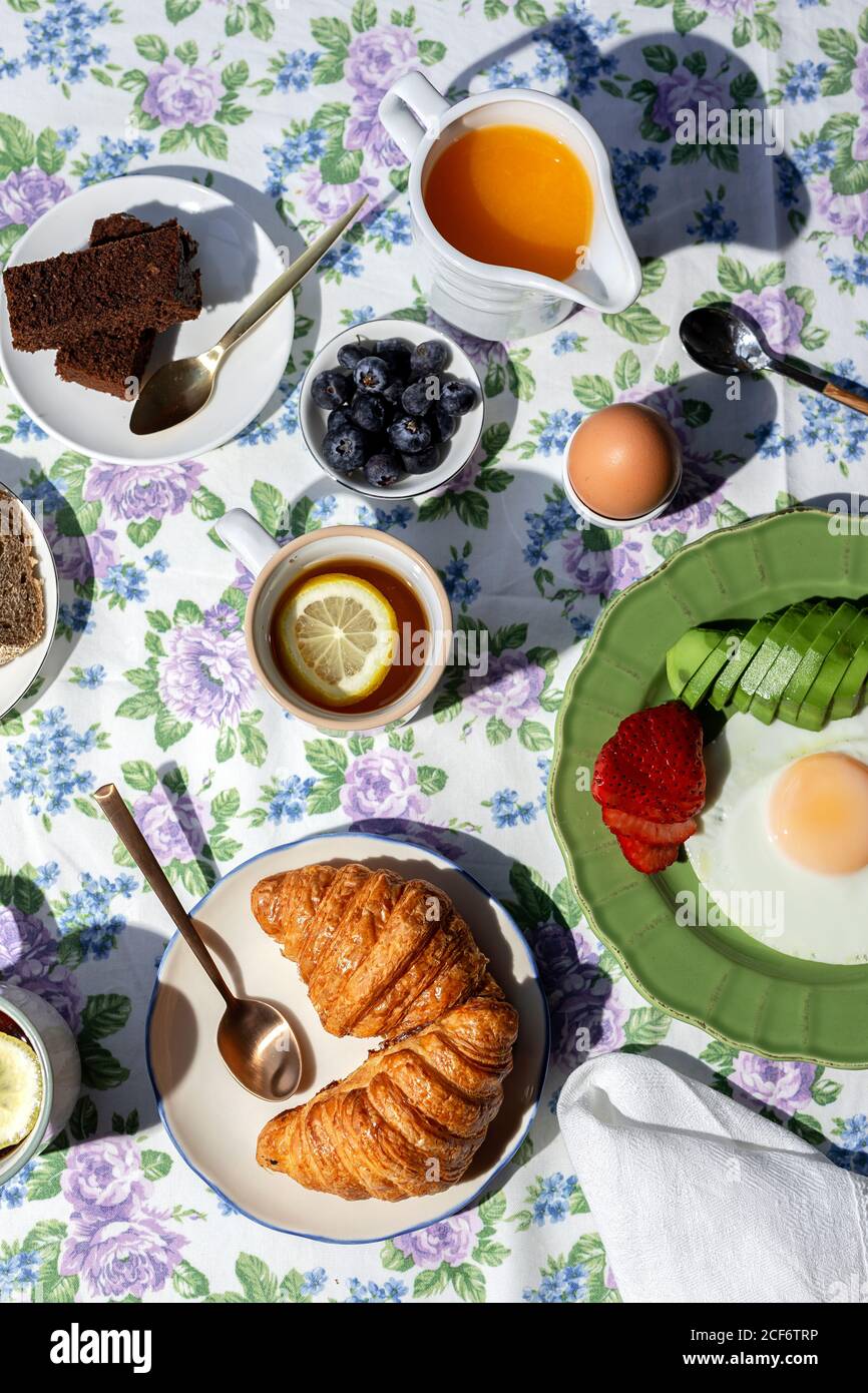 Petit Dejeuner Complet Et Sain Fait Maison Au Soleil Avec œufs Avocat Fraises Myrtilles Gateau Eponge Croissants Pain Grille The Cafe Et Jus D Orange Photo Stock Alamy