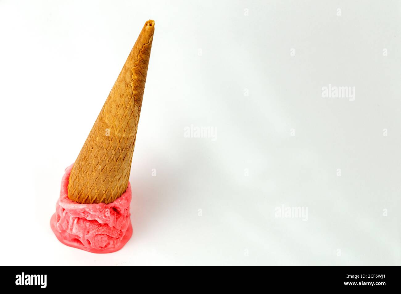 Cône de gaufrage avec une cuillère de glace aux fraises arrière-plan blanc Banque D'Images