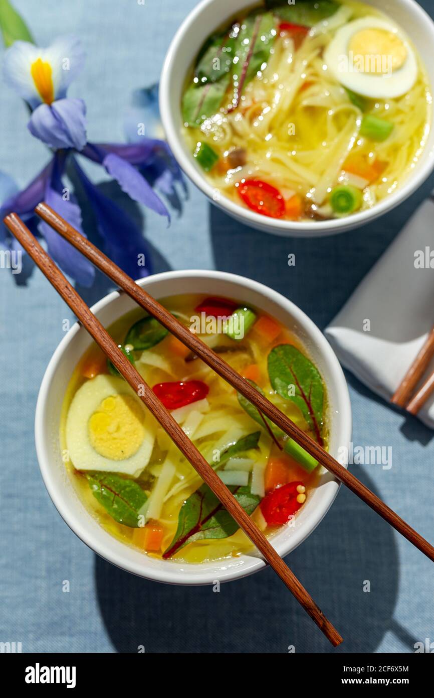 Une soupe orientale de nouilles ramen saines avec shiitake, épinards, carottes, œufs et piments sur la table du restaurant Banque D'Images
