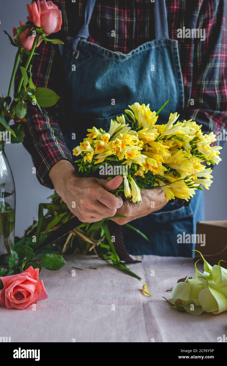 fleuriste professionnel méconnaissable faisant des bouquets de différents types. Roses. Fleurs jaunes. Criques Banque D'Images