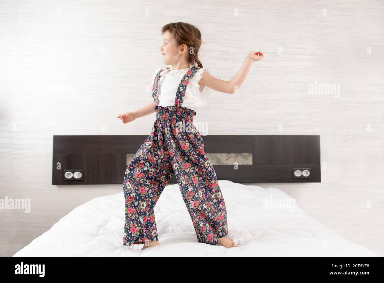 Cheerful girl jumping on bed Banque D'Images