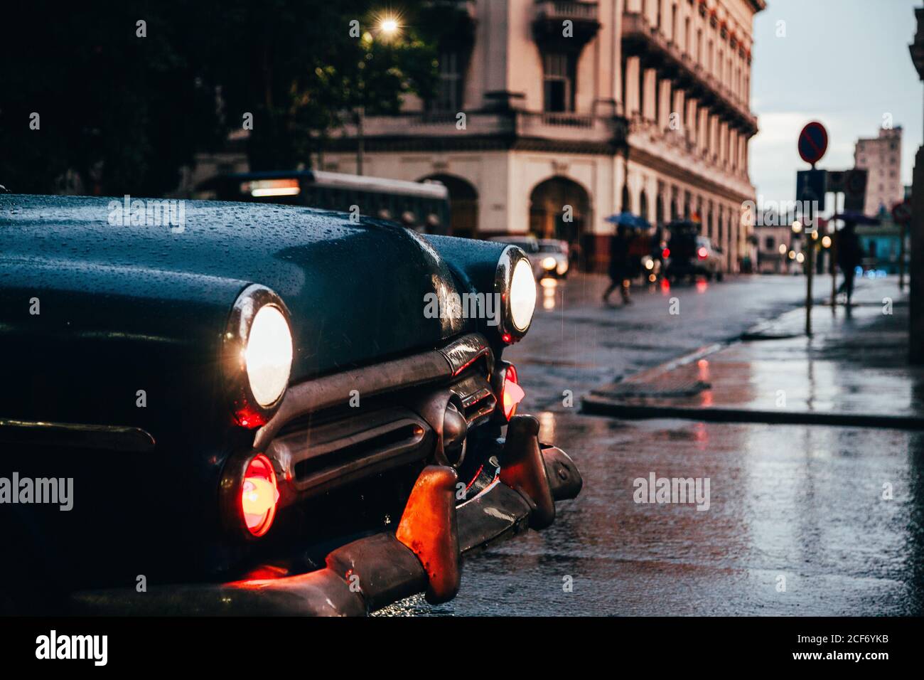 Capot de voiture vintage bleue avec feux allumés et rouge la vieille voiture est en mouvement en arrière-plan par temps pluvieux Cuba Banque D'Images