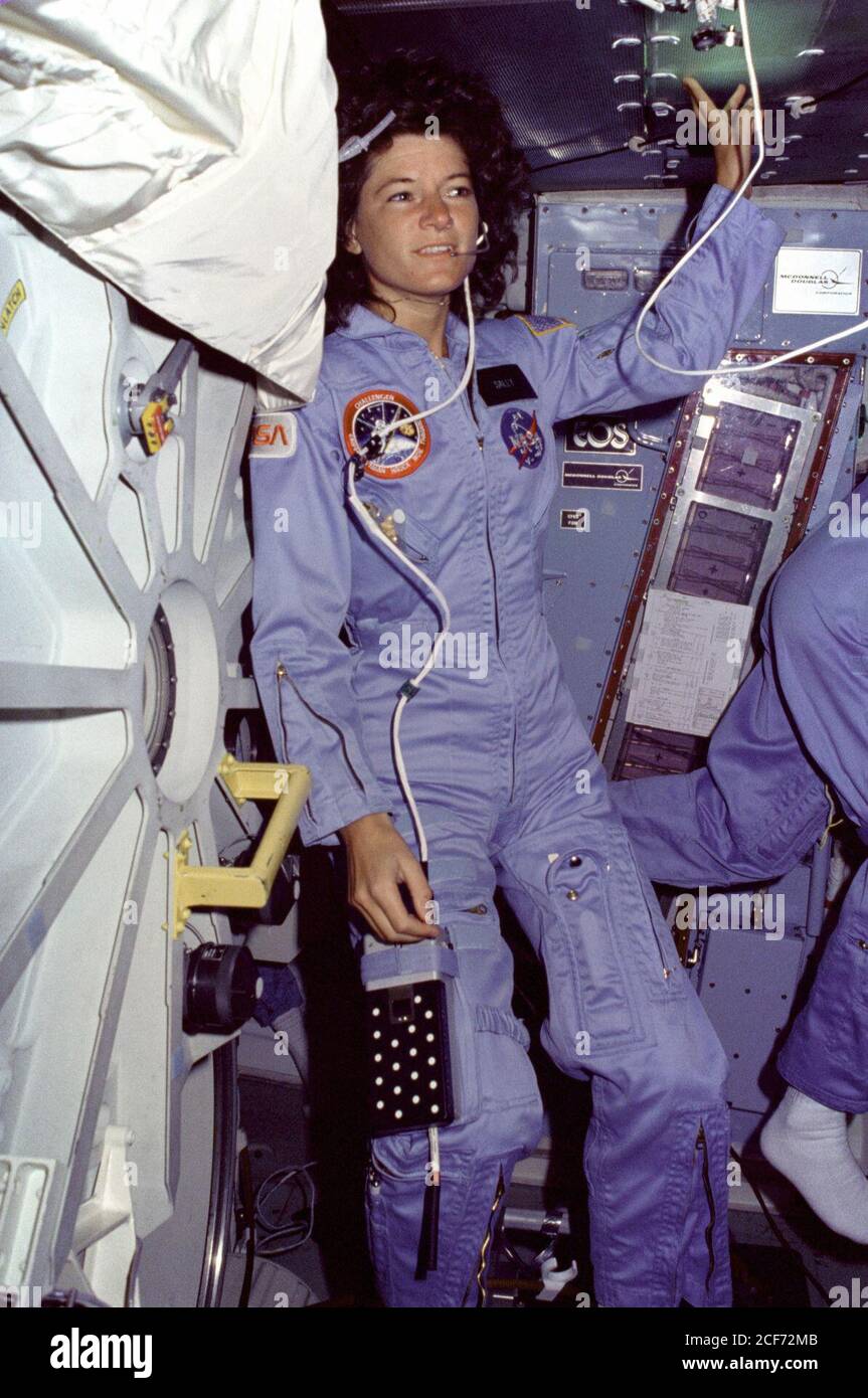 Sur le pont intermédiaire de Challenger, Sally Ride, spécialiste de mission  (MS), porte des combinaisons de vol bleu clair et un casque de  communication, flotte le long de la trappe de verrouillage
