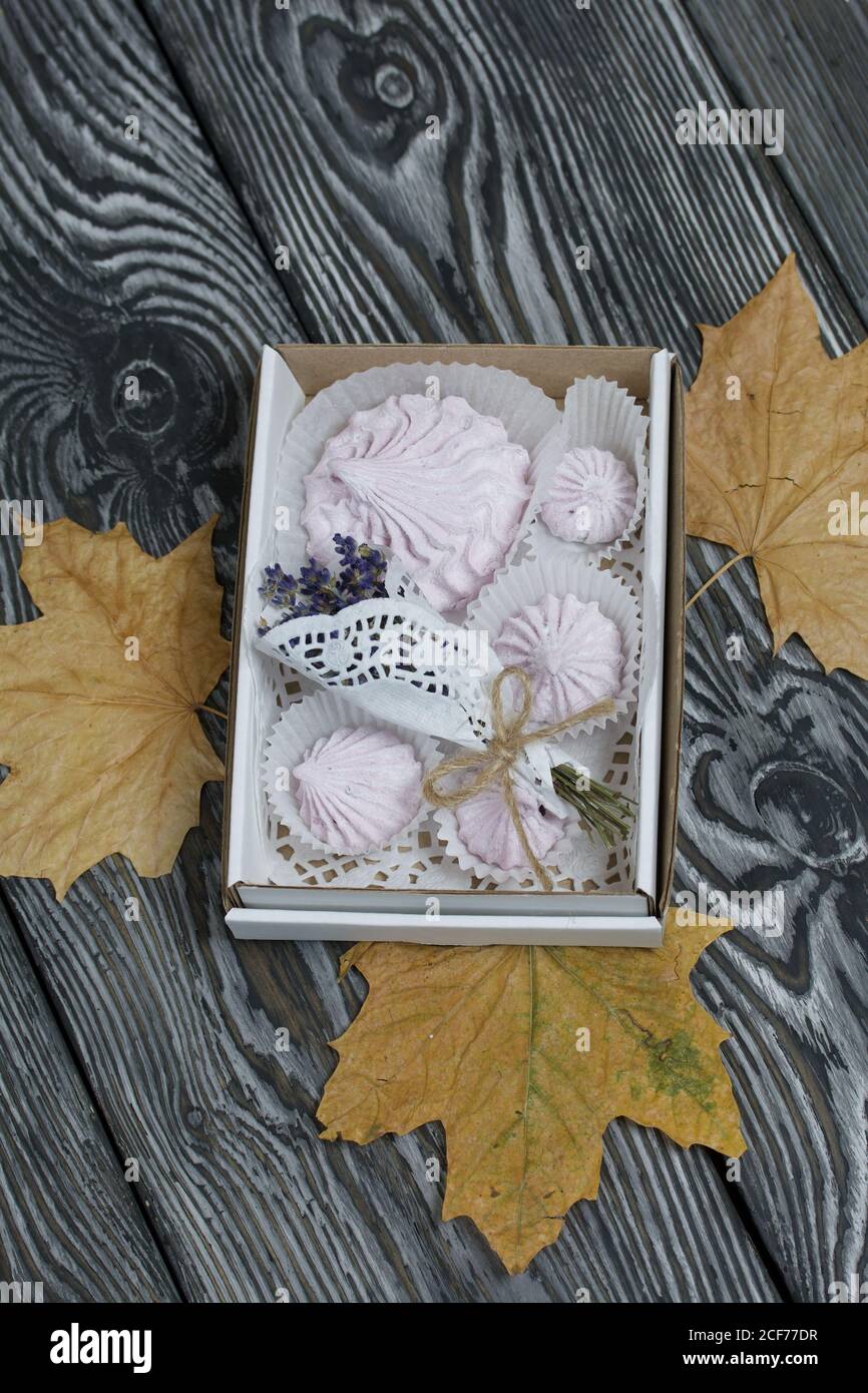 Zephyr dans une boîte, un bouquet de lavande et de feuilles d'érable séchées. Sur des planches de pin peintes. Banque D'Images