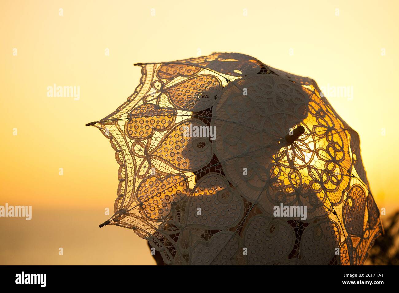 Vue latérale de la silhouette du fiancé avec tenue de voile de mariée parapluie vintage en soirée sur fond flou Banque D'Images