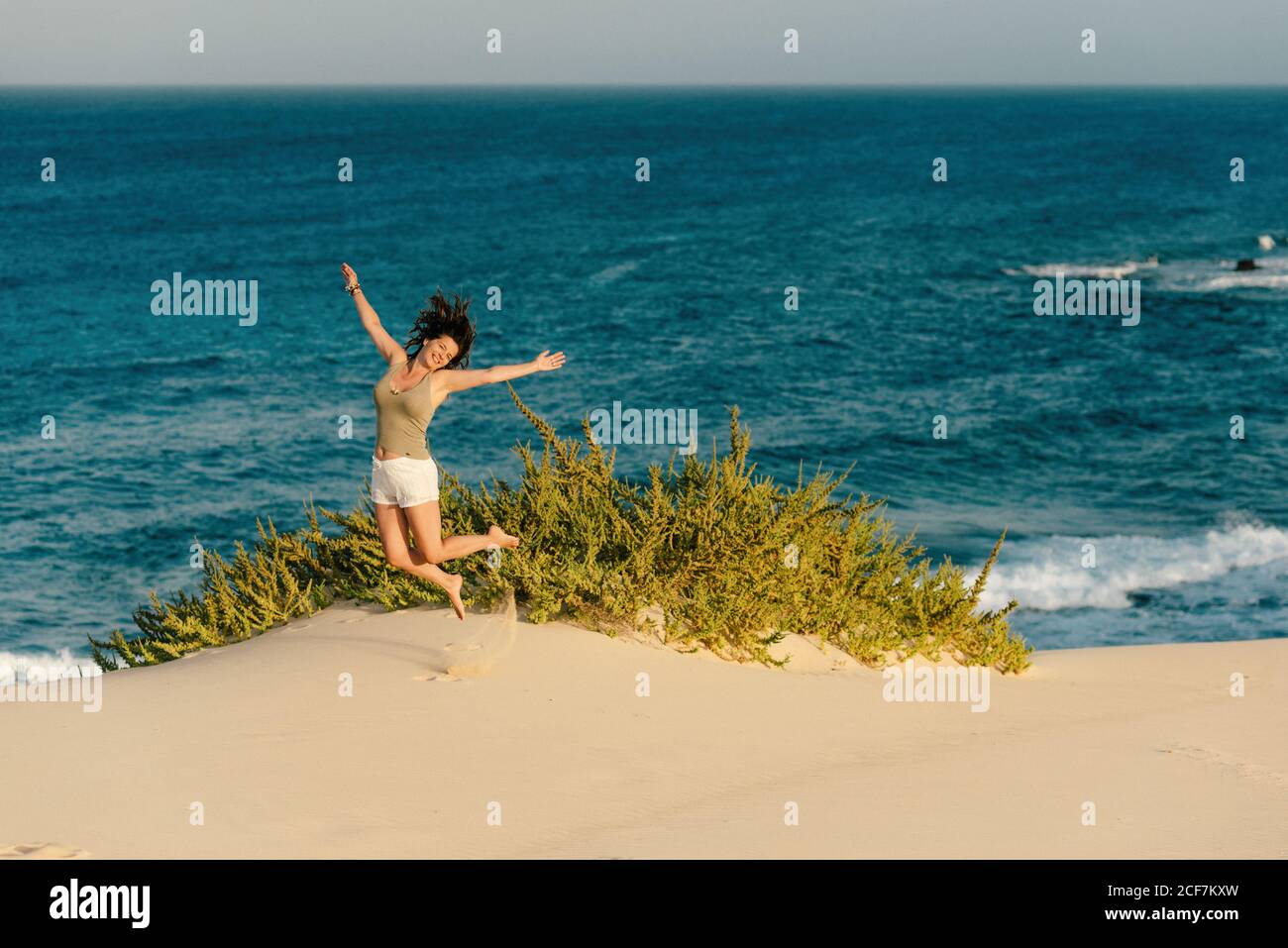 Femme active en short blanc marchant plage de sable Banque D'Images