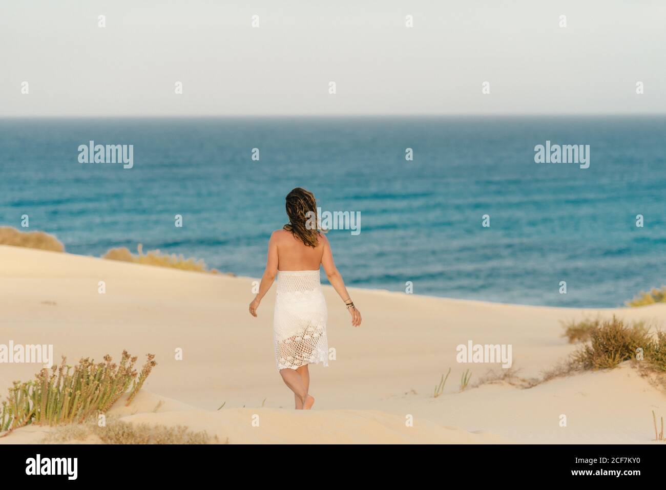 Femme active en short blanc marchant plage de sable Banque D'Images