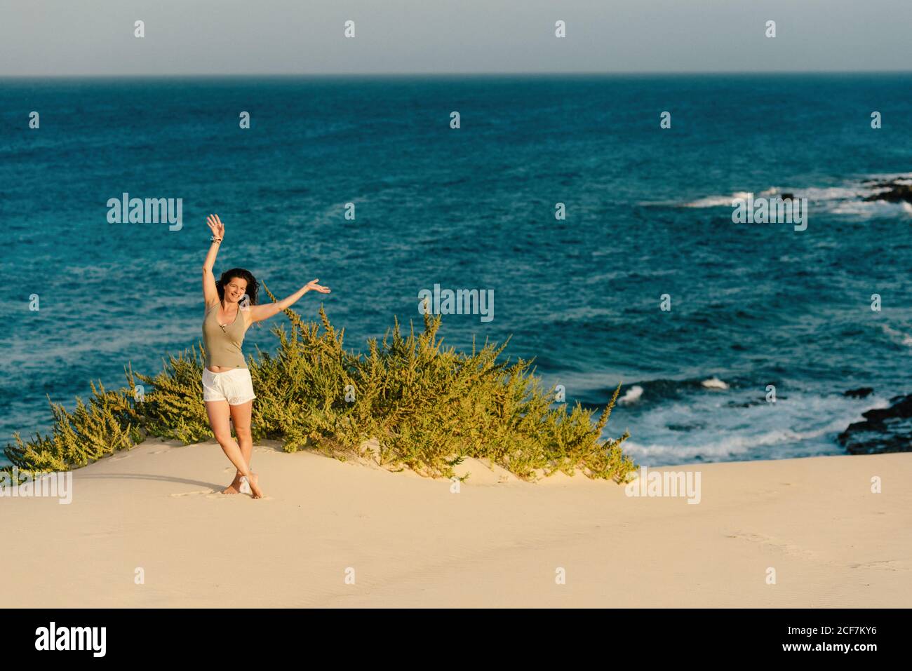 Femme active en short blanc marchant plage de sable Banque D'Images