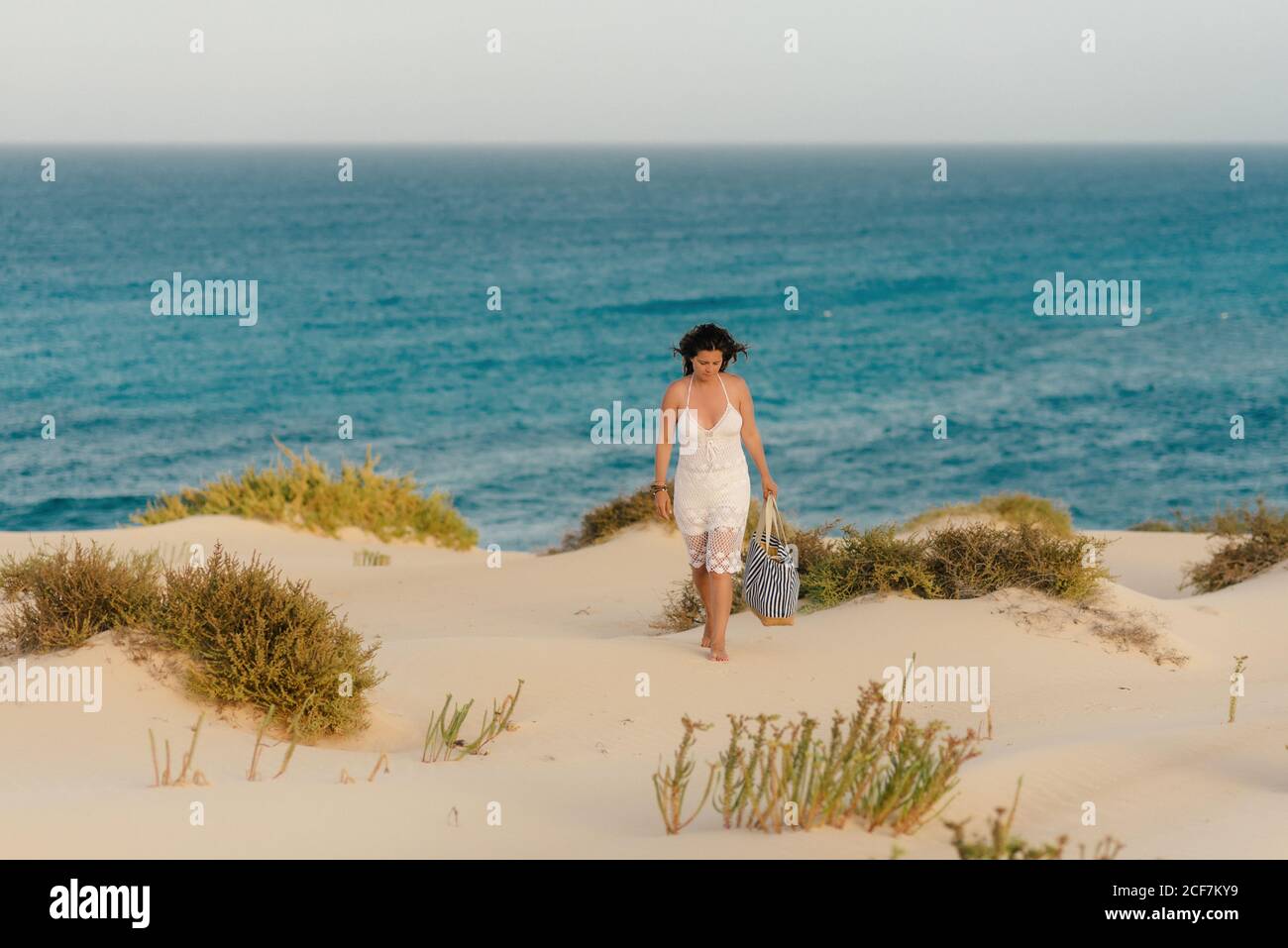 Femme active en short blanc marchant plage de sable Banque D'Images