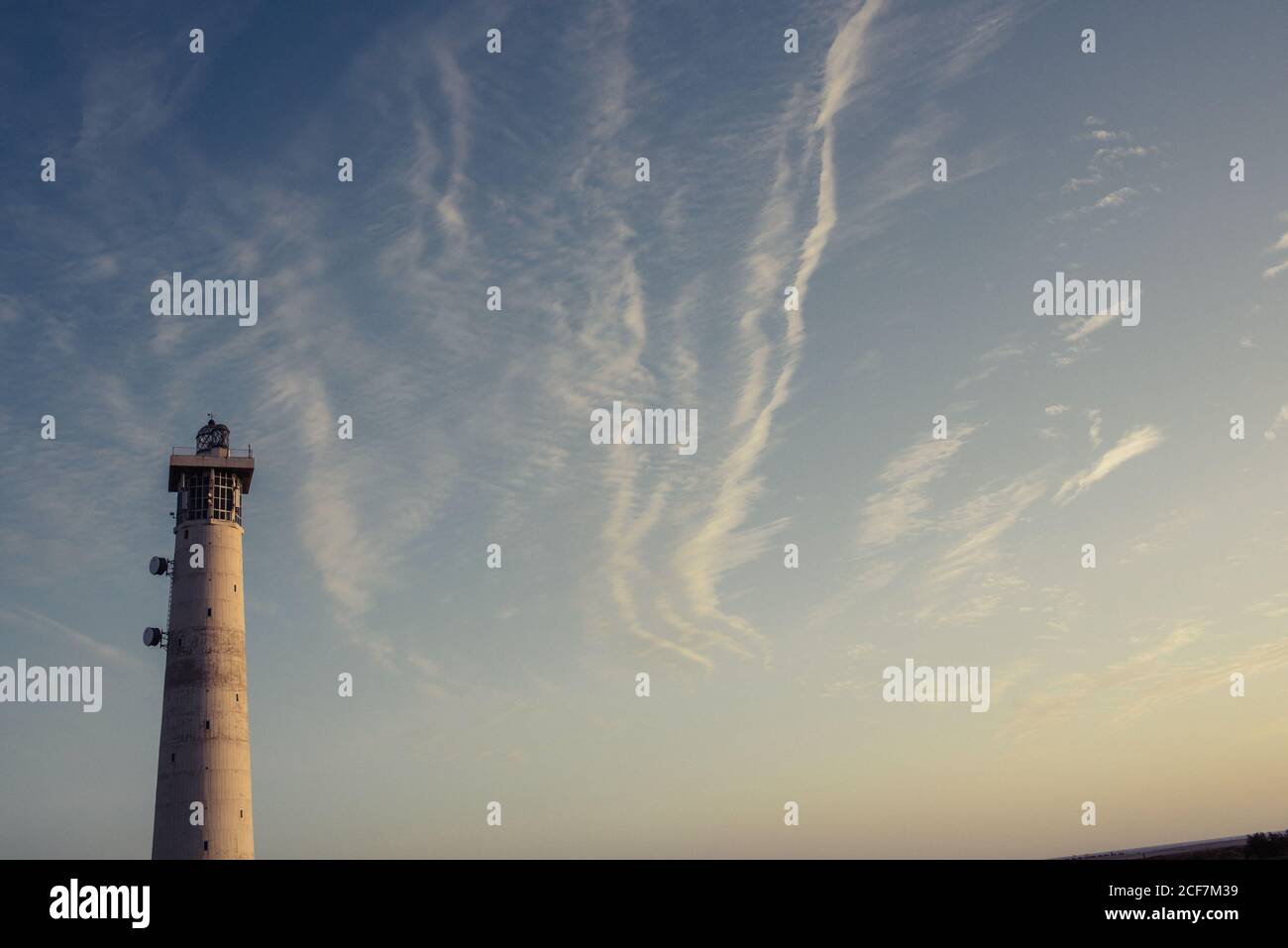 Tour ronde de phare gris s'élevant jusqu'au ciel Banque D'Images