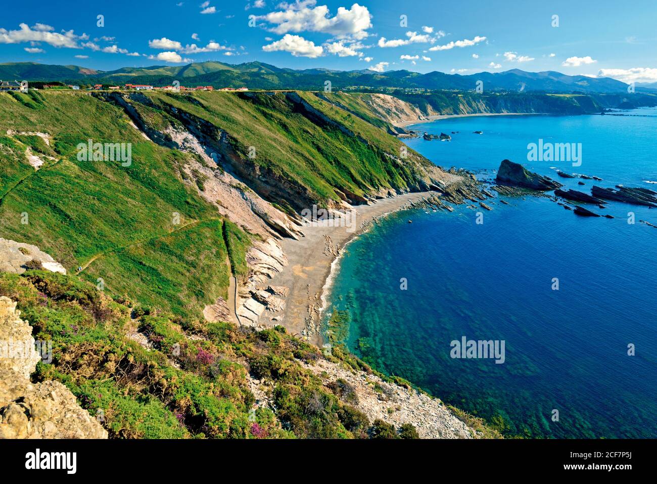 Superbe vue sur le bord de mer avec des falaises verdoyantes et des montagnes dans le arrière-plan Banque D'Images