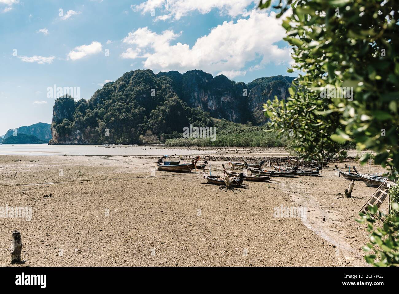 Depuis le dessus d'une incroyable plage de sable vide avec pêche en bois bateaux parmi les plantes tropicales vertes avec des montagnes sur fond Vietnam Banque D'Images