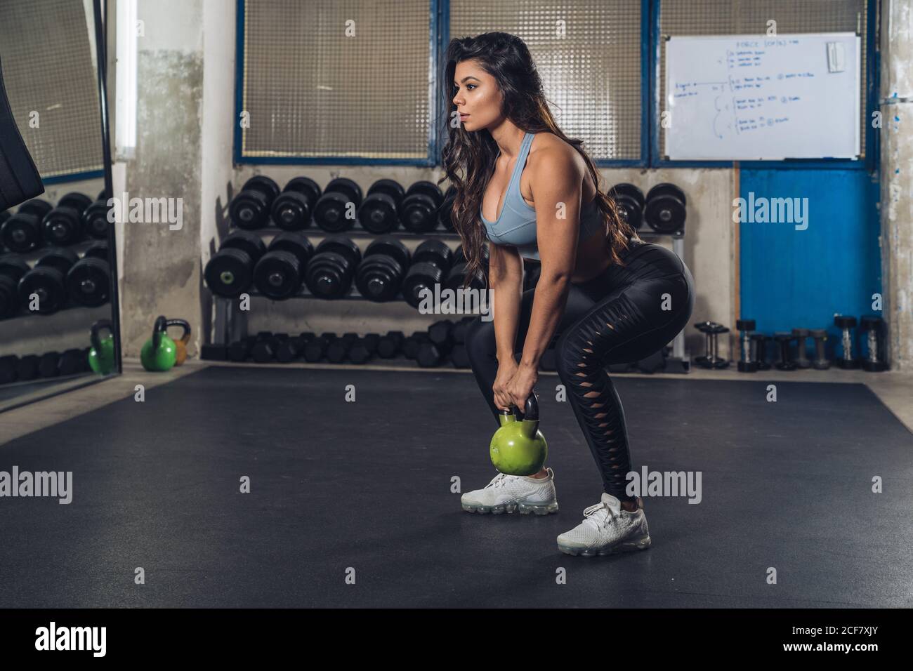 Femme musclée de lever le poids dans la salle de gym Banque D'Images