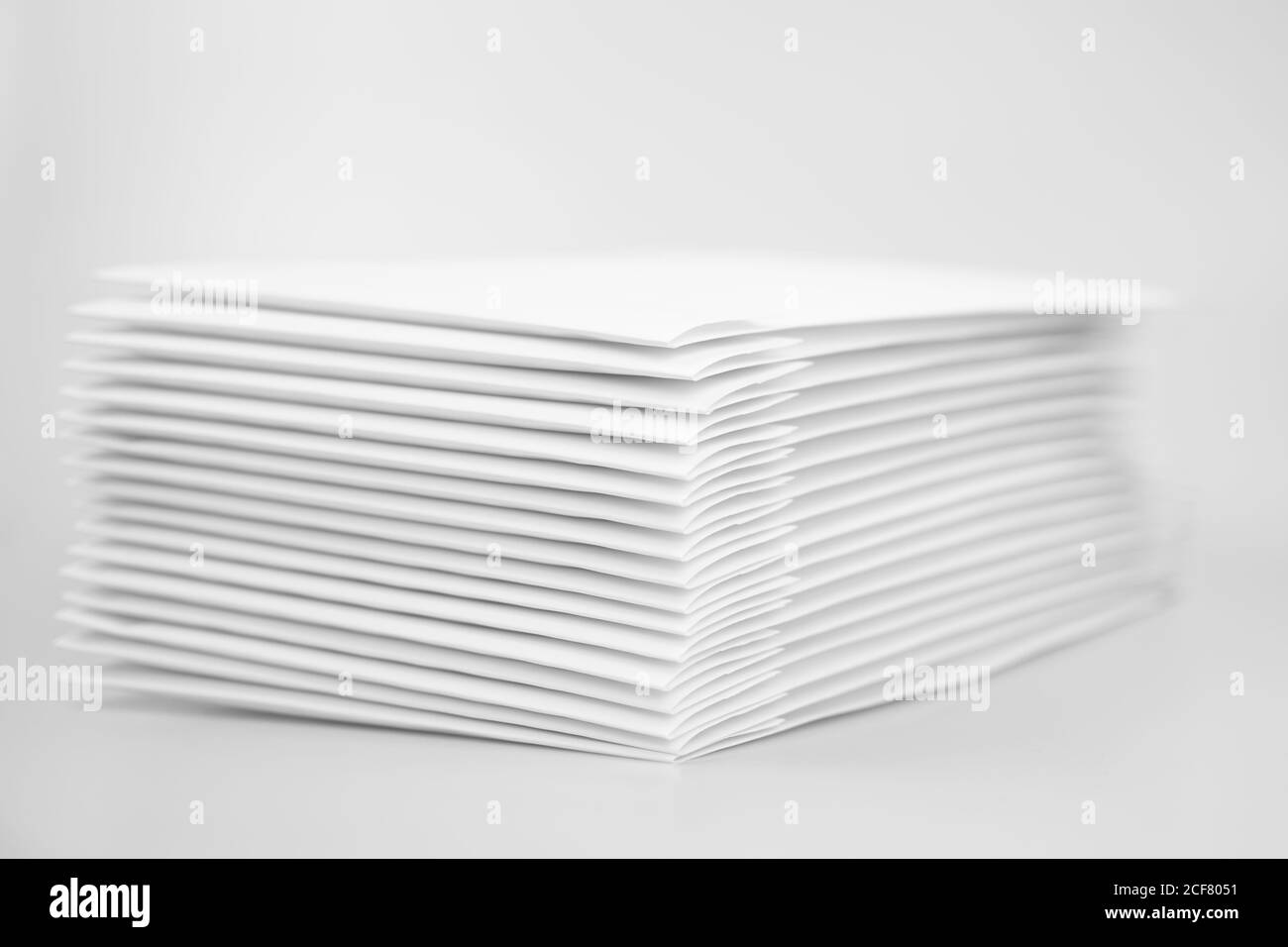 Pile d'enveloppes papier sur fond blanc. Pile de DVD et de CD dans des enveloppes blanches. Fournitures de bureau Banque D'Images