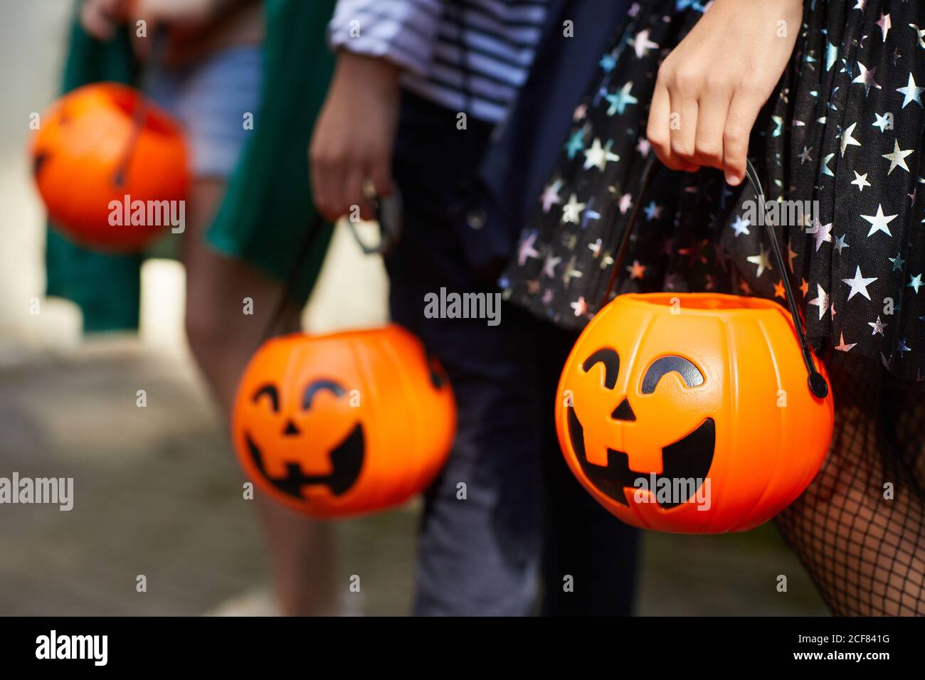 Gros plan d'enfants avec des sacs de citrouilles jouant des trucs ou des friandises à l'extérieur Banque D'Images