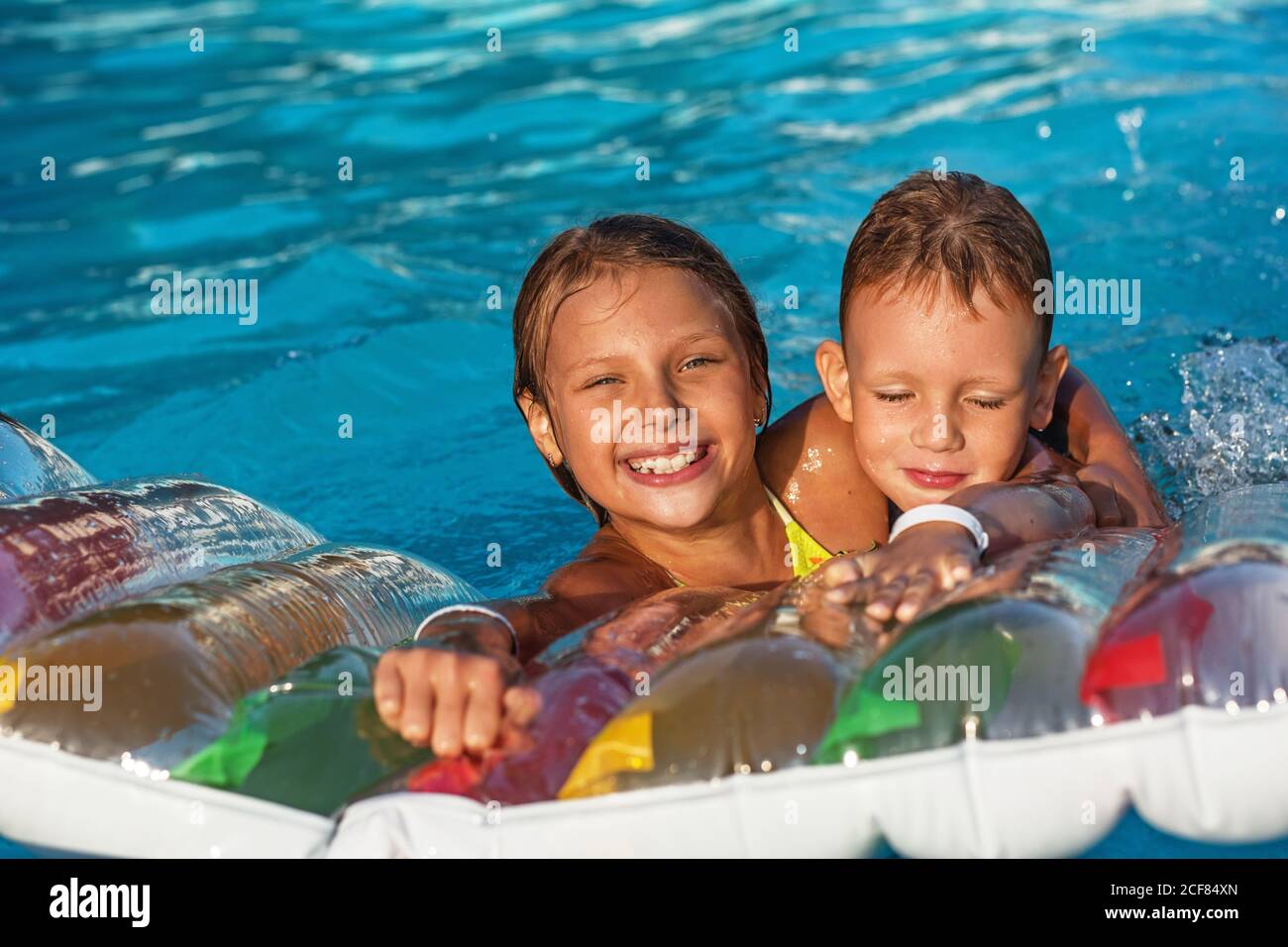 Petits Enfants Sur Un Matelas Gonflable Dans La Piscine Les Enfants Souriants Jouent Et S Amusent Dans La Piscine Avec Matelas A Air Garcon Et Fille Jouant Photo Stock Alamy