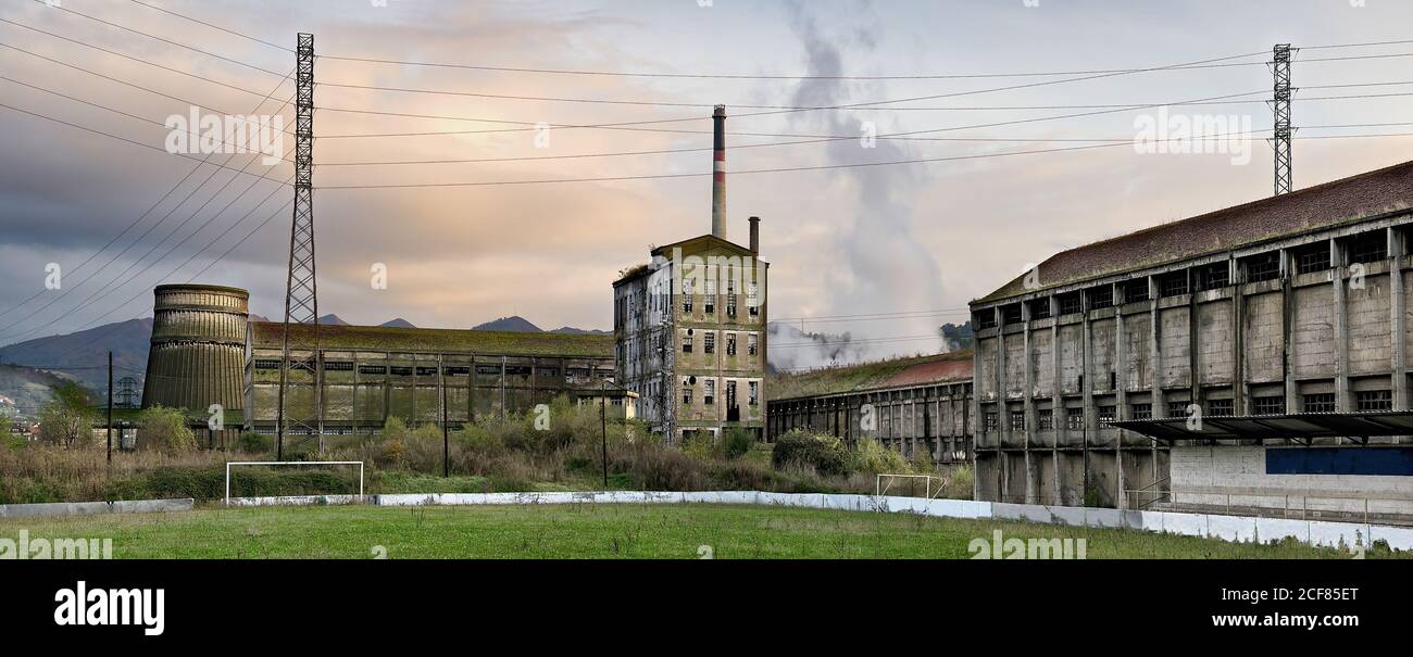 Vue en grand angle de l'ancienne usine abandonnée avec un gris sorbby Bâtiments et tuyaux situés dans la campagne espagnole dans les Asturies Banque D'Images