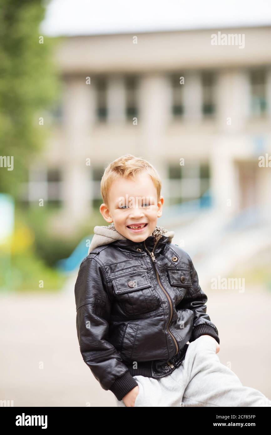 portrait d'un adorable petit garçon portant une veste en cuir noir. Enfants  urbains. Mains dans les poches. Perte de dents primaires chez les enfants  Photo Stock - Alamy