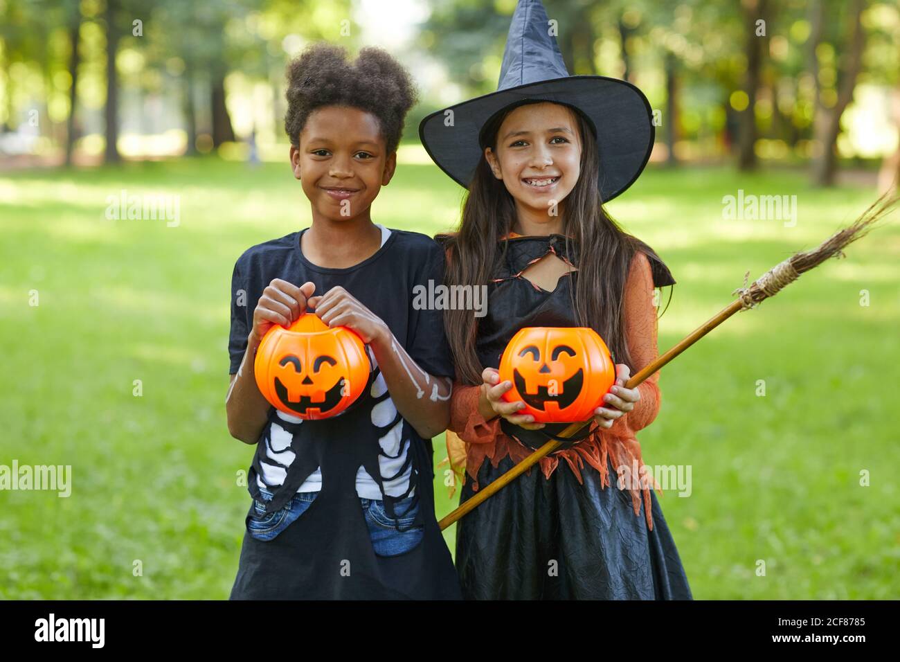 Portrait de deux amis heureux souriant à l'appareil photo pendant Halloween faites la fête dans le parc à l'extérieur Banque D'Images