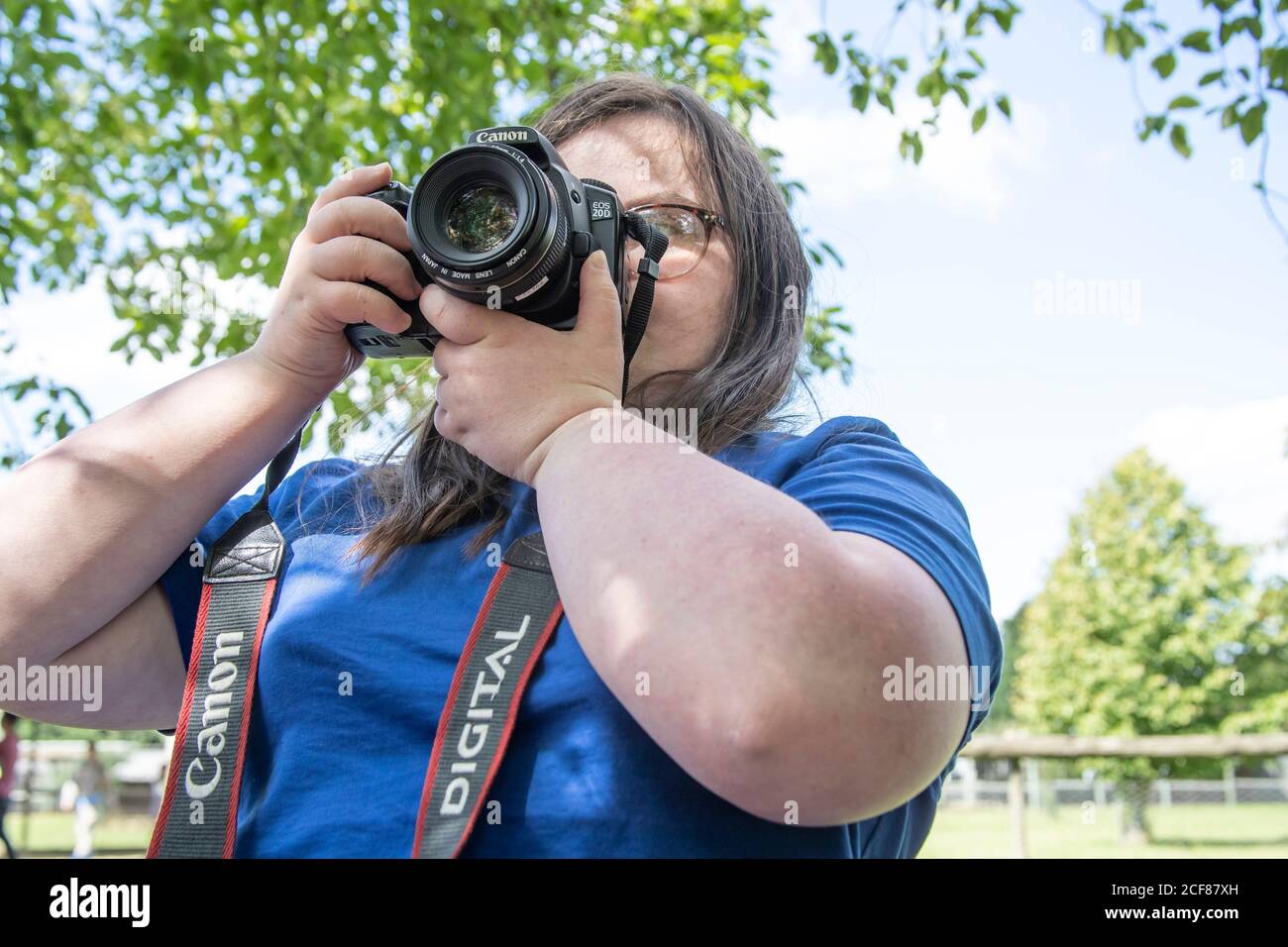 Jeune fille avec le syndrome de Downs prenant des photos avec un Canon EOS 20D lors d'une journée au zoo de Hamerton, dans le Huntingdonshire. Banque D'Images