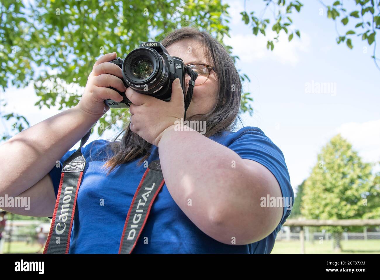 Jeune fille avec le syndrome de Downs prenant des photos avec un Canon EOS 20D lors d'une journée au zoo de Hamerton, dans le Huntingdonshire. Banque D'Images