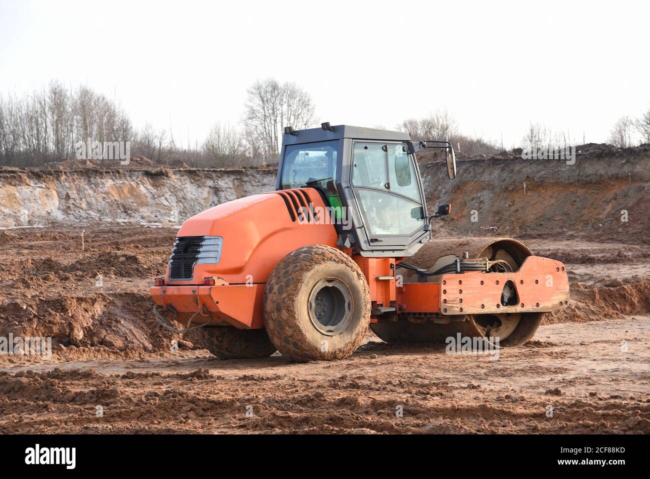 Vibration rouleau de route à cylindre unique nivelant le sol pour la fondation. Compacteur de sol pour la pose d'asphalte sur route sur le chantier de construction. Communication routière Banque D'Images