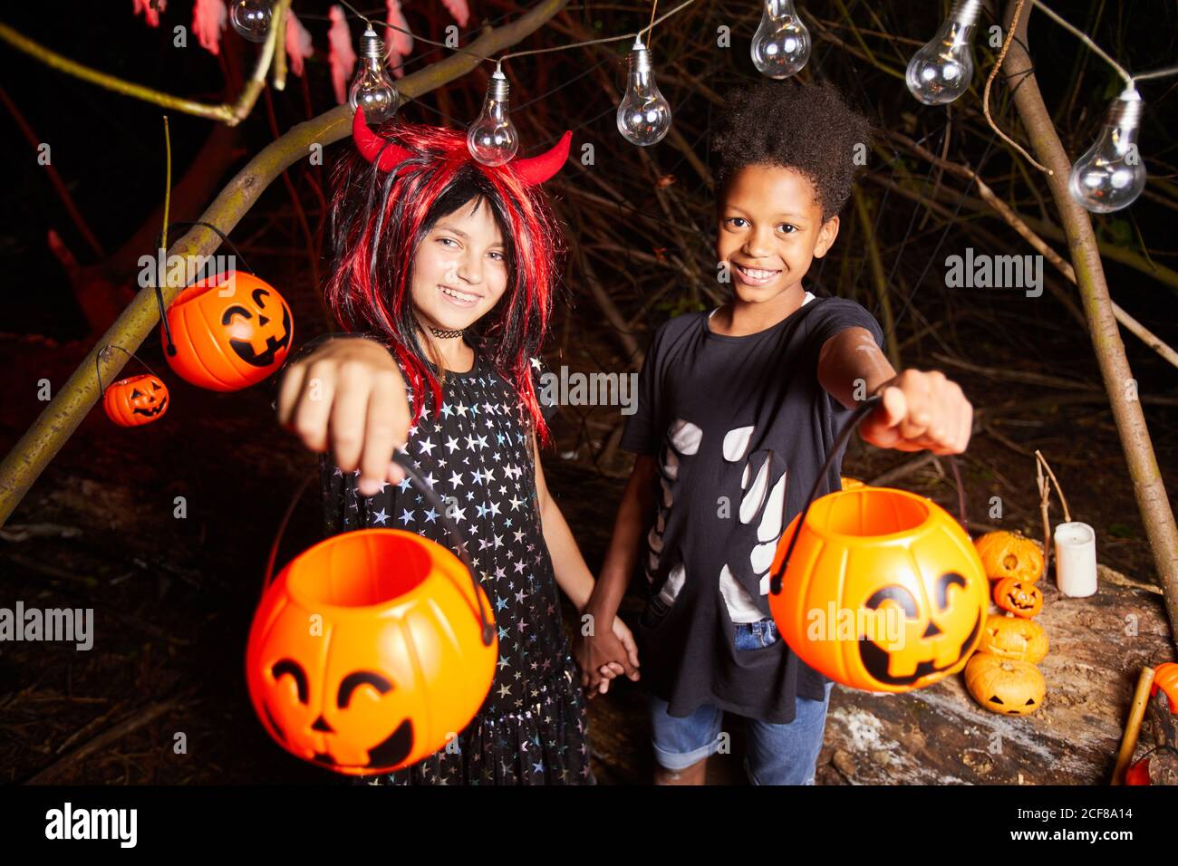 Portrait de deux enfants heureux en costumes tenant les paniers et En attente de gâteries pendant la fête d'Halloween Banque D'Images