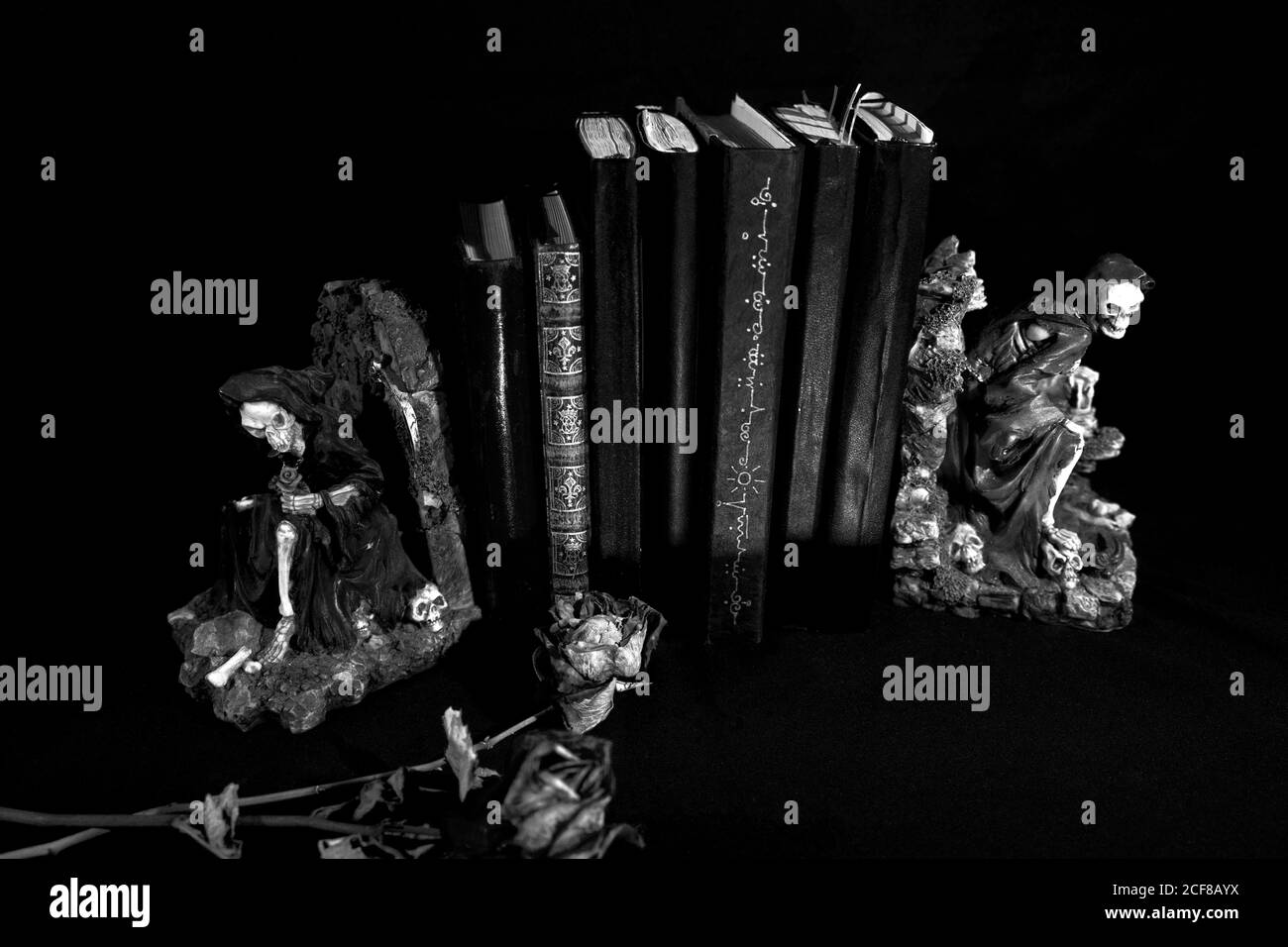 Sept journaux intimes avec des livres de goth. Deux figures de la couche. Deux roses rouges mortes. Banque D'Images