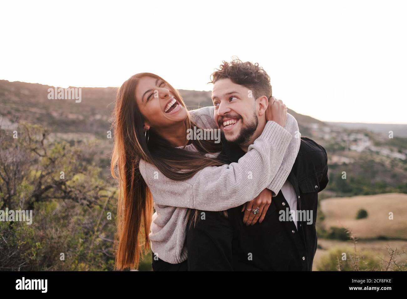 Copain et petite amie joyeux tenant les mains dans la région montagneuse pendant rire à plaisanter ensemble et s'amuser Banque D'Images