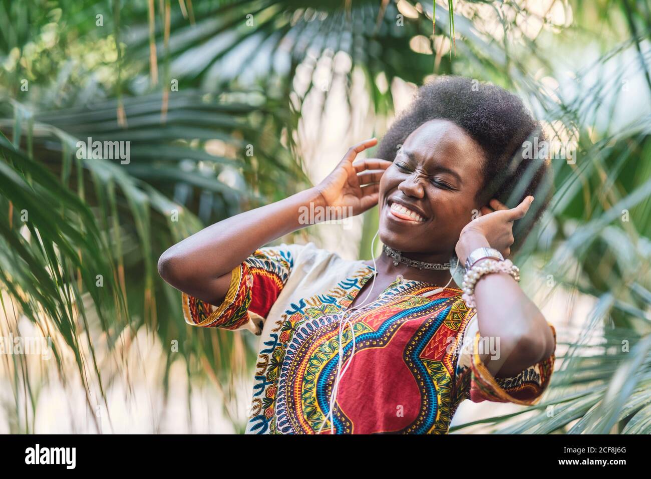 Femme noire souriante à l'écoute de musique Banque D'Images