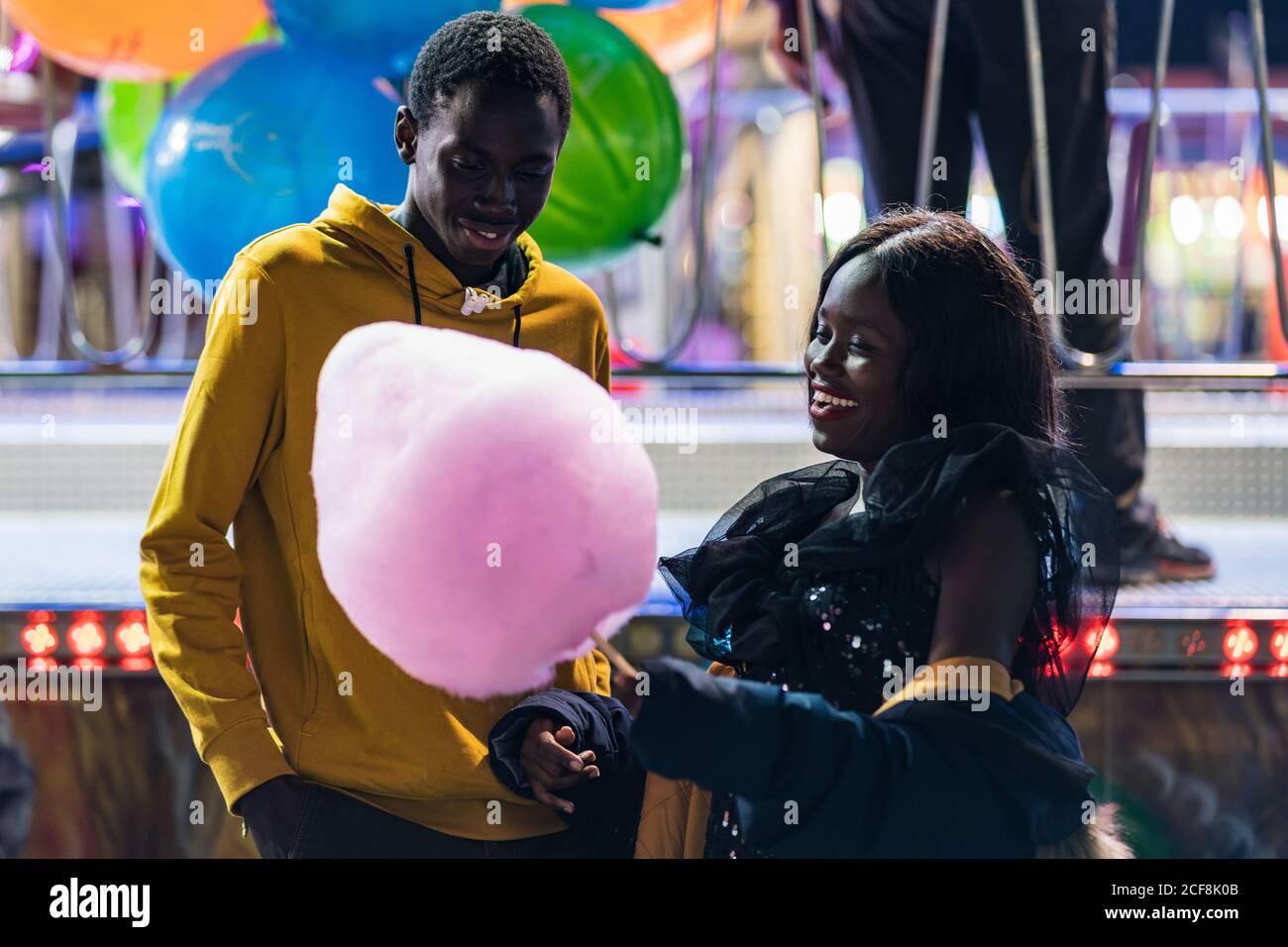 Joyeux couple noir mangeant de la soie de bonbons Banque D'Images