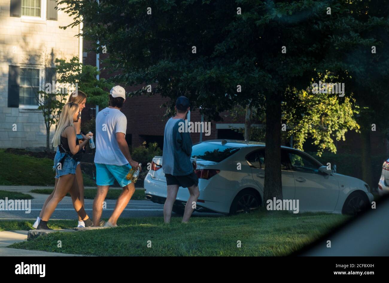 Bloomington, Indiana, États-Unis. 19 août 2020. Les étudiants portent des bières tout en marchant le long de Washington Street après qu'une fête ait été interrompue par la police une semaine avant le début des cours pendant la pandémie du coronavirus.plus de 30 maisons grecques de l'université de l'Indiana sont actuellement en quarantaine. Crédit : Jeremy Hogan/SOPA Images/ZUMA Wire/Alay Live News Banque D'Images