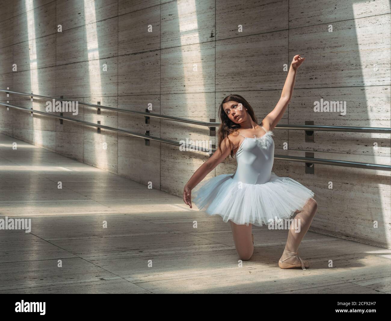 Ballerine en blanc ballet tutu effectuant des exercices au rail in lumière  solaire contrastée Photo Stock - Alamy