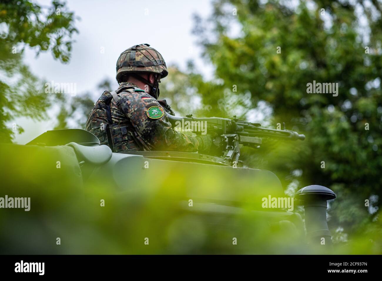 04 septembre 2020, Rhénanie-du-Nord-Westphalie, Münster: ATTENTION: LOCK NOTE: 13:00 HRS - UN soldat de l'I. corps allemand/néerlandais se tient avec une mitrailleuse dans une ouverture de toit d'un véhicule militaire. La Force multinationale aura 25 ans cette année et conduira jusqu'à 60,000 soldats en 2021 en tant qu'équipe de commandement de l'OTAN. Avec le ministre néerlandais de la Défense, Kramp-Karrenbauer s'adressera aux membres du corps. Photo: Guido Kirchner/dpa Banque D'Images